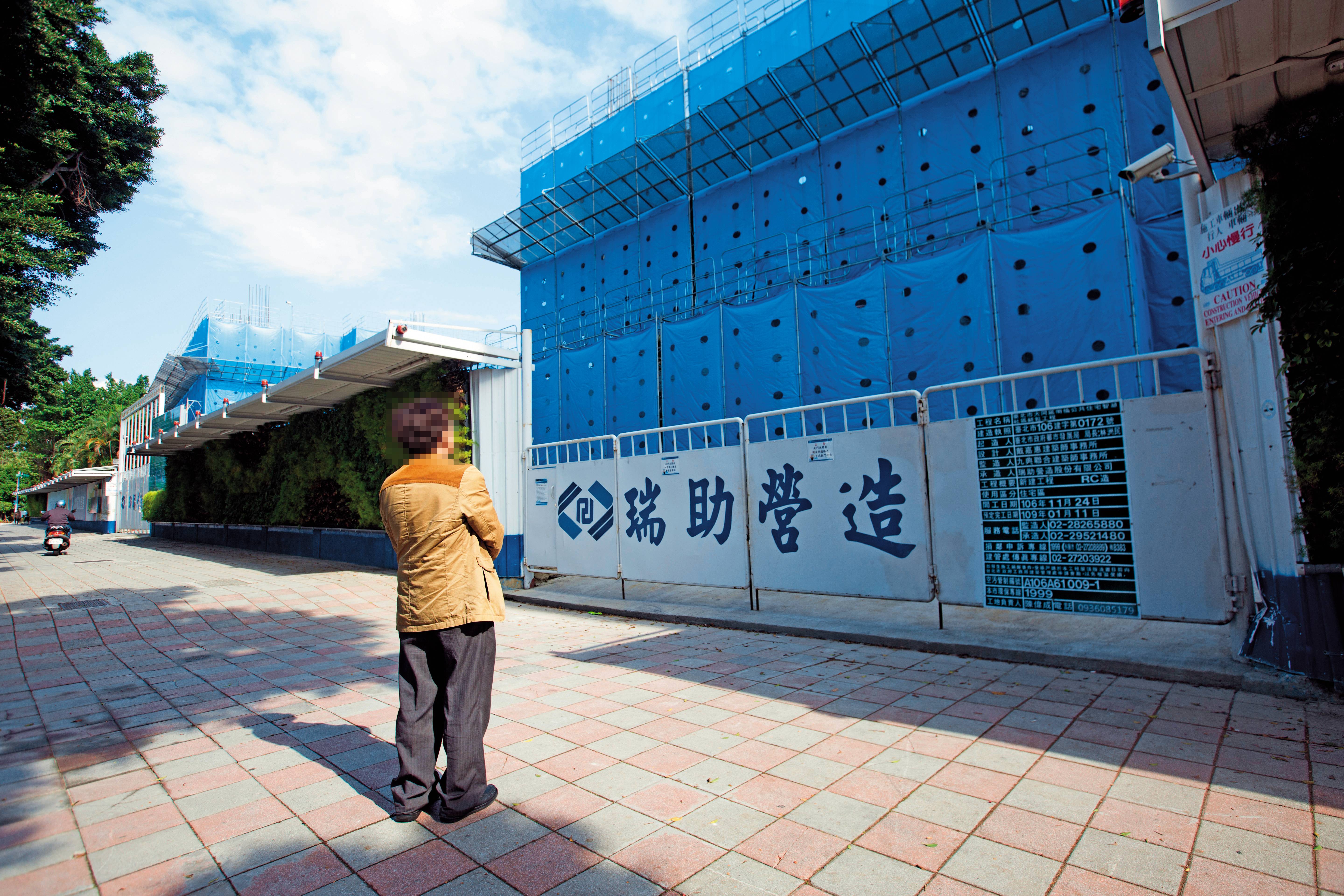 下包商阿慶站在明倫公宅前，怒控瑞助營造違法亂紀。