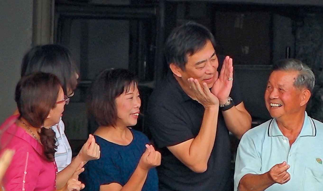 11/11 10:44 指導擺姿勢　楊家駿（右2）參觀台南「芳榮米廠」時，還熱情教老闆擺姿勢拍照。