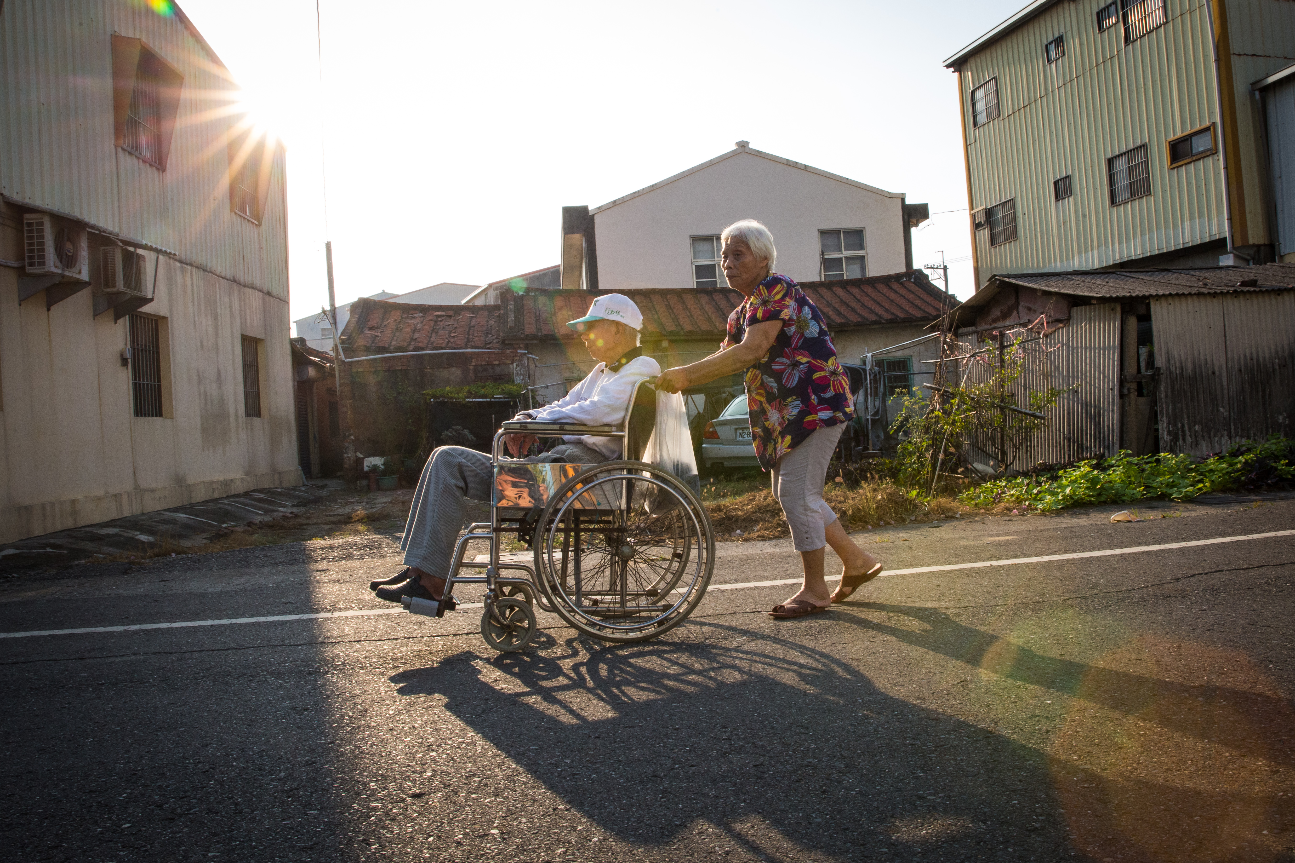 吳連珠推著輪椅帶翁興雄出外散步。他願意坐輪椅，對吳連珠來說已是幸運的事。