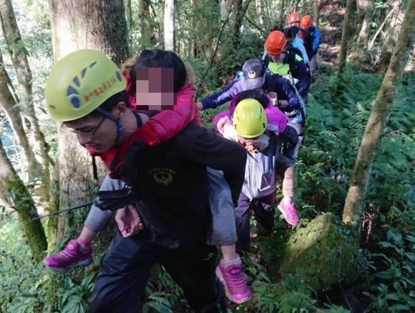 昨天傍晚有2名女子、2名兒童攀登新竹縣北得拉曼山失聯,還好今天早上就被尋獲,其中2名兒童由搜救人員揹下山。(消防局提供)