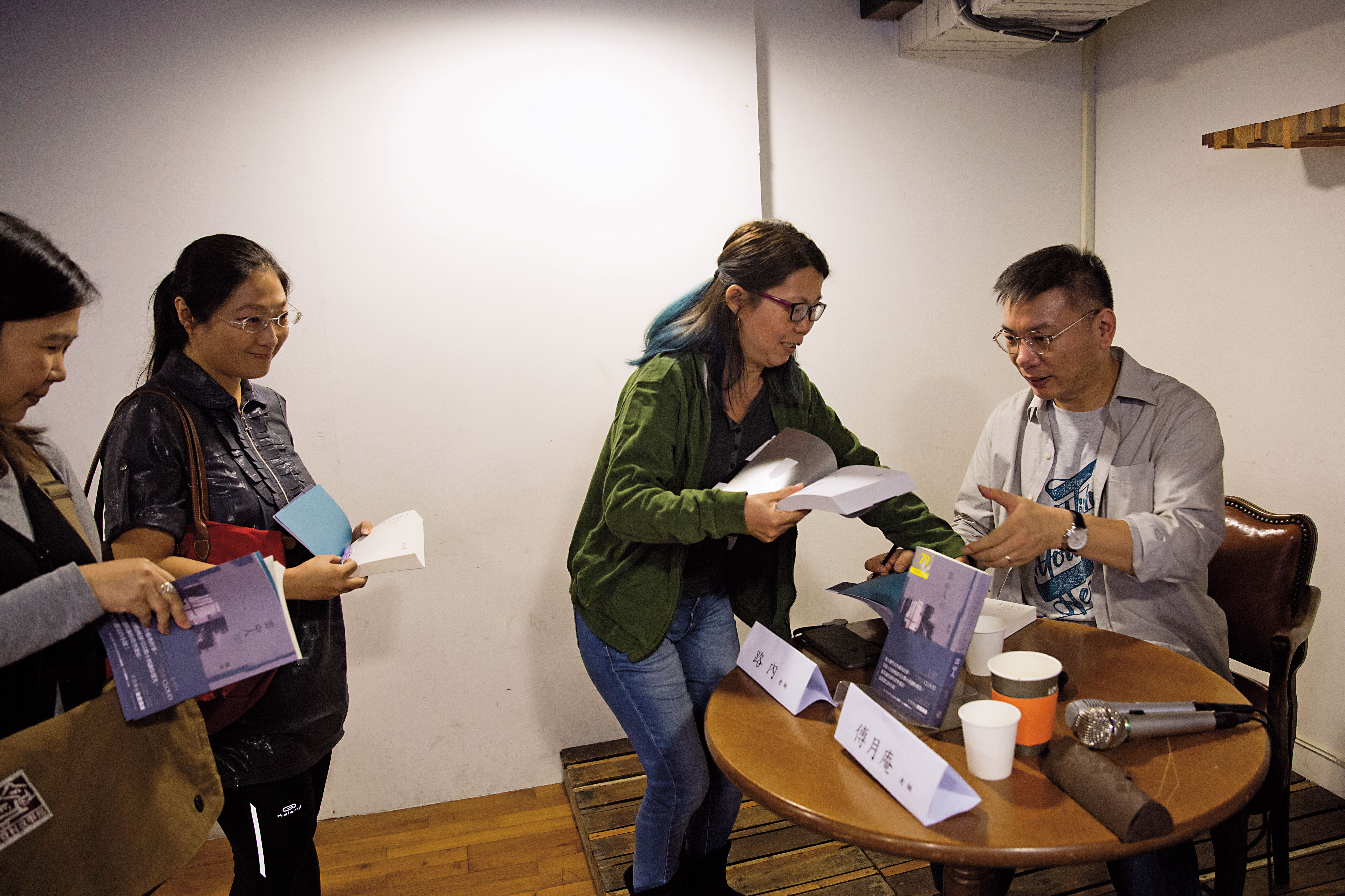 座談會後，路內（右）替讀者簽書。戴著銀邊眼鏡的他，不開口搞笑時，遠看倒像是工程師。（路內提供）