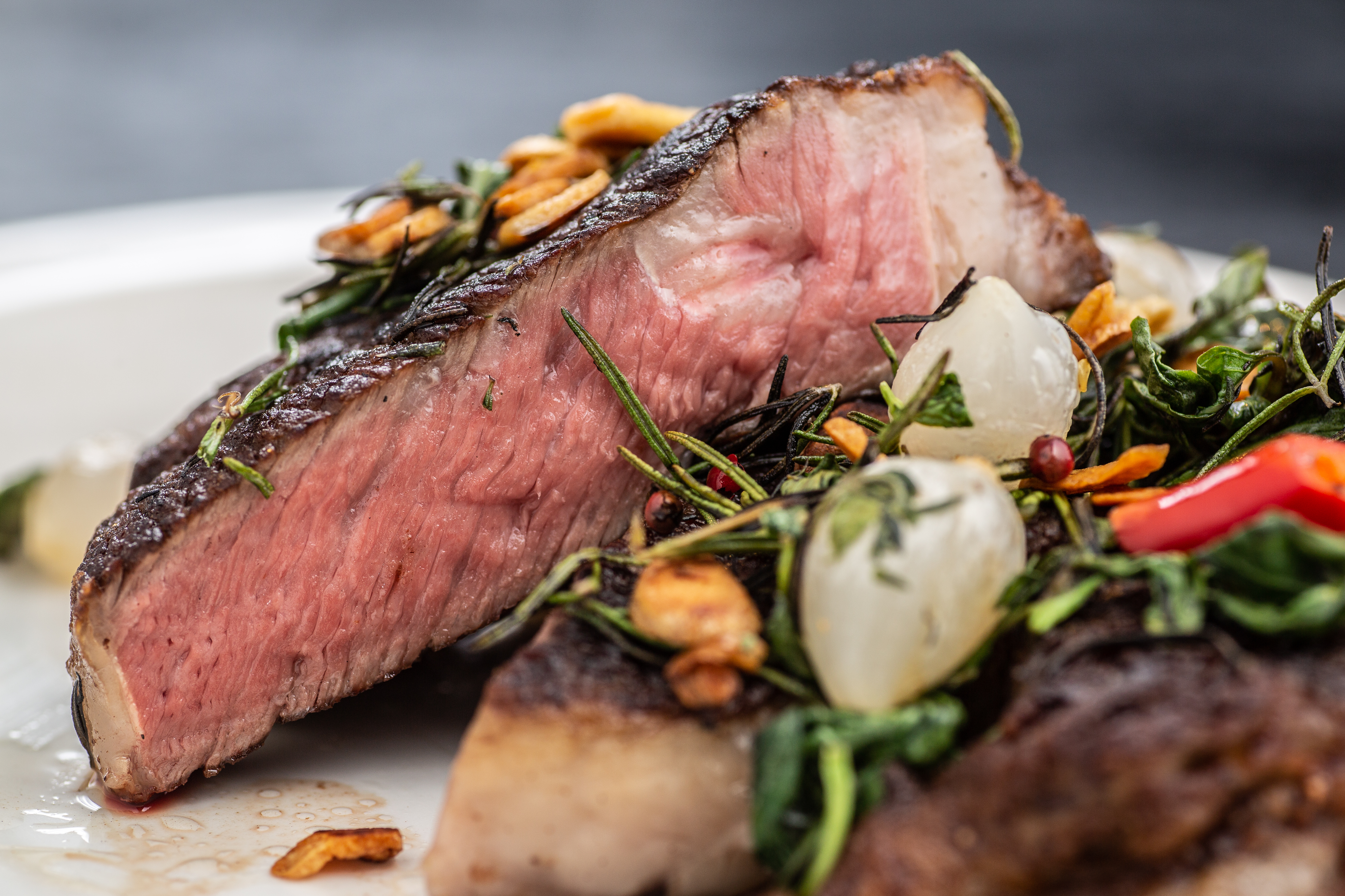 表皮微焦，肉質油潤的「美國肋眼牛排」，搭配九層塔，辣椒，鮮美惹味。（雙人套餐價3,580元／24oz）