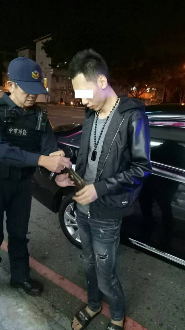 莊男掏出皮夾拿證件，又被眼尖的特警發現裡藏有2顆小藥丸。（警方提供）