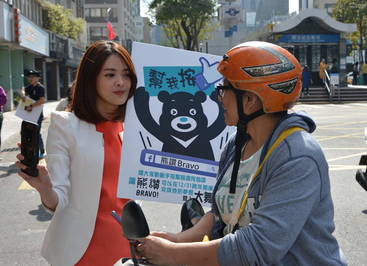 華視主播莊雨潔在街頭熱情幫熊讚拉票。（華視提供）