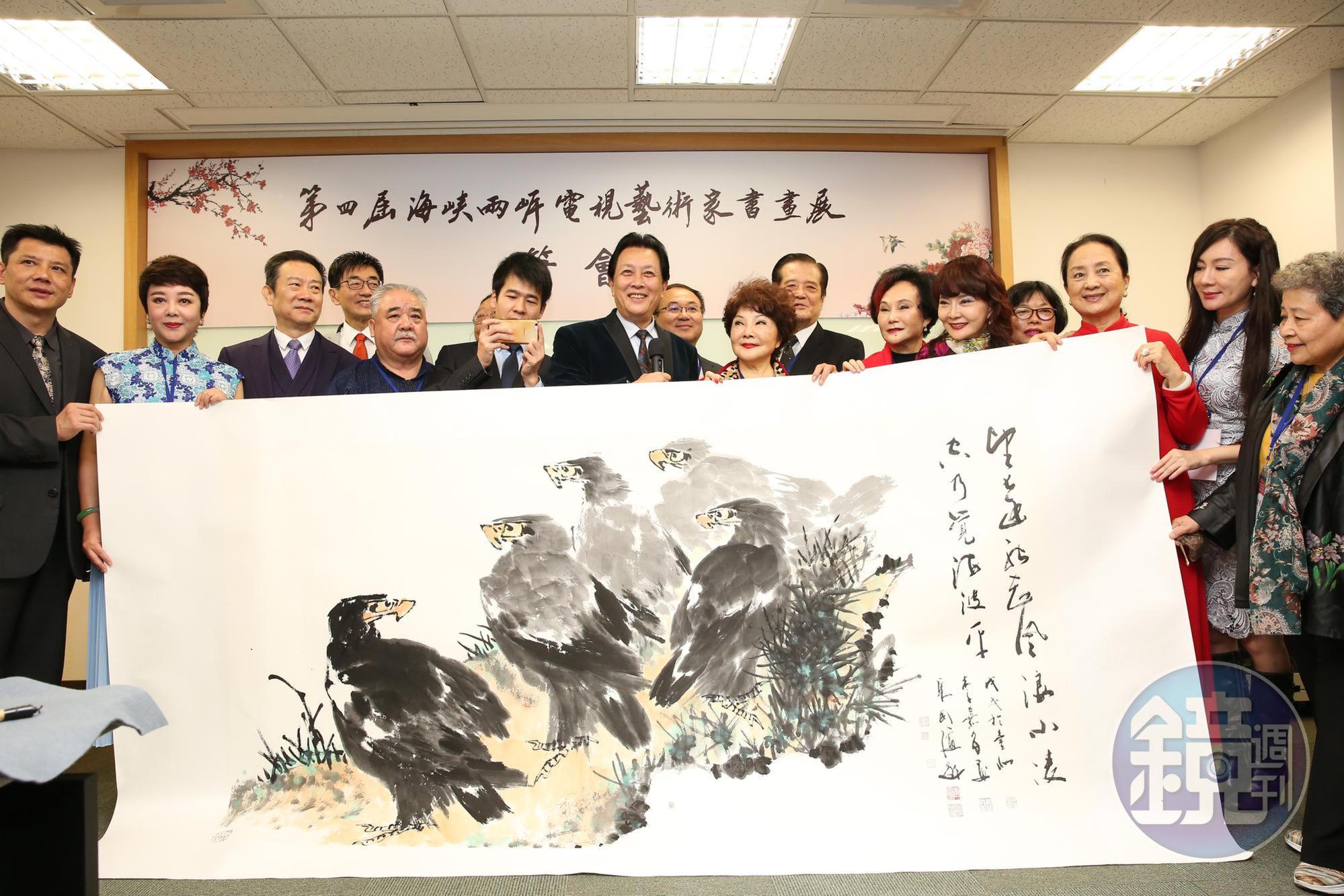 唐國強代表將大陸代表團集體創作的畫作送給主辦的中華廣播電視節目製作商業同業公會理事長汪威江，右邊的字即是他現場寫下的題款。