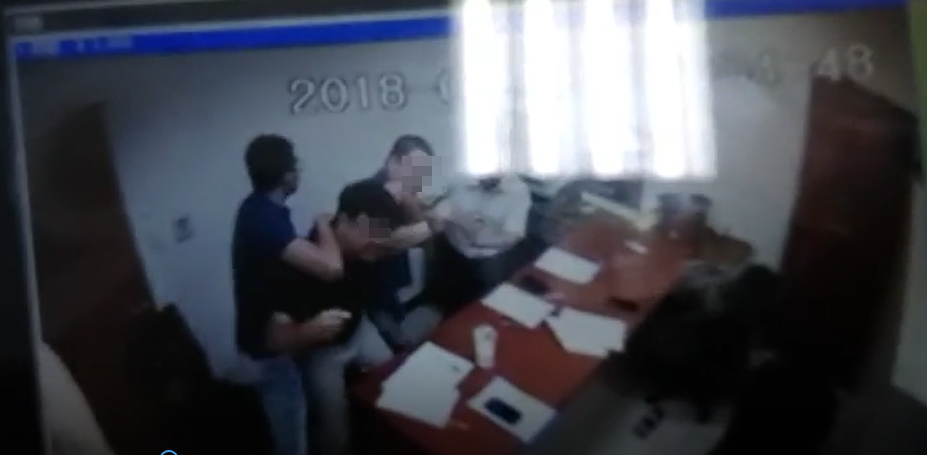 陳男（左1藍衣者）繞過桌子企圖攻擊曹男（左3），所幸被同事隔開。（讀者提供）