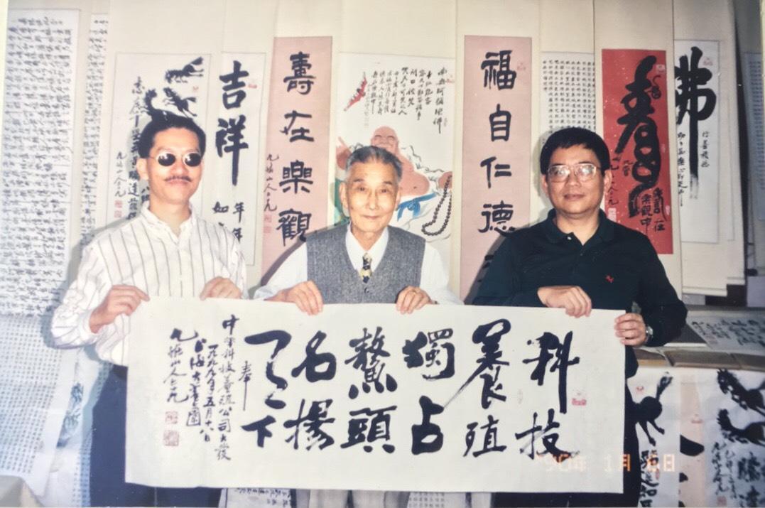 1999年兩人剛創業時拜訪書法家九怪山人,他特地寫下:「科技養殖獨占鰲頭名揚天下」贈予兩人。(張永聲提供)