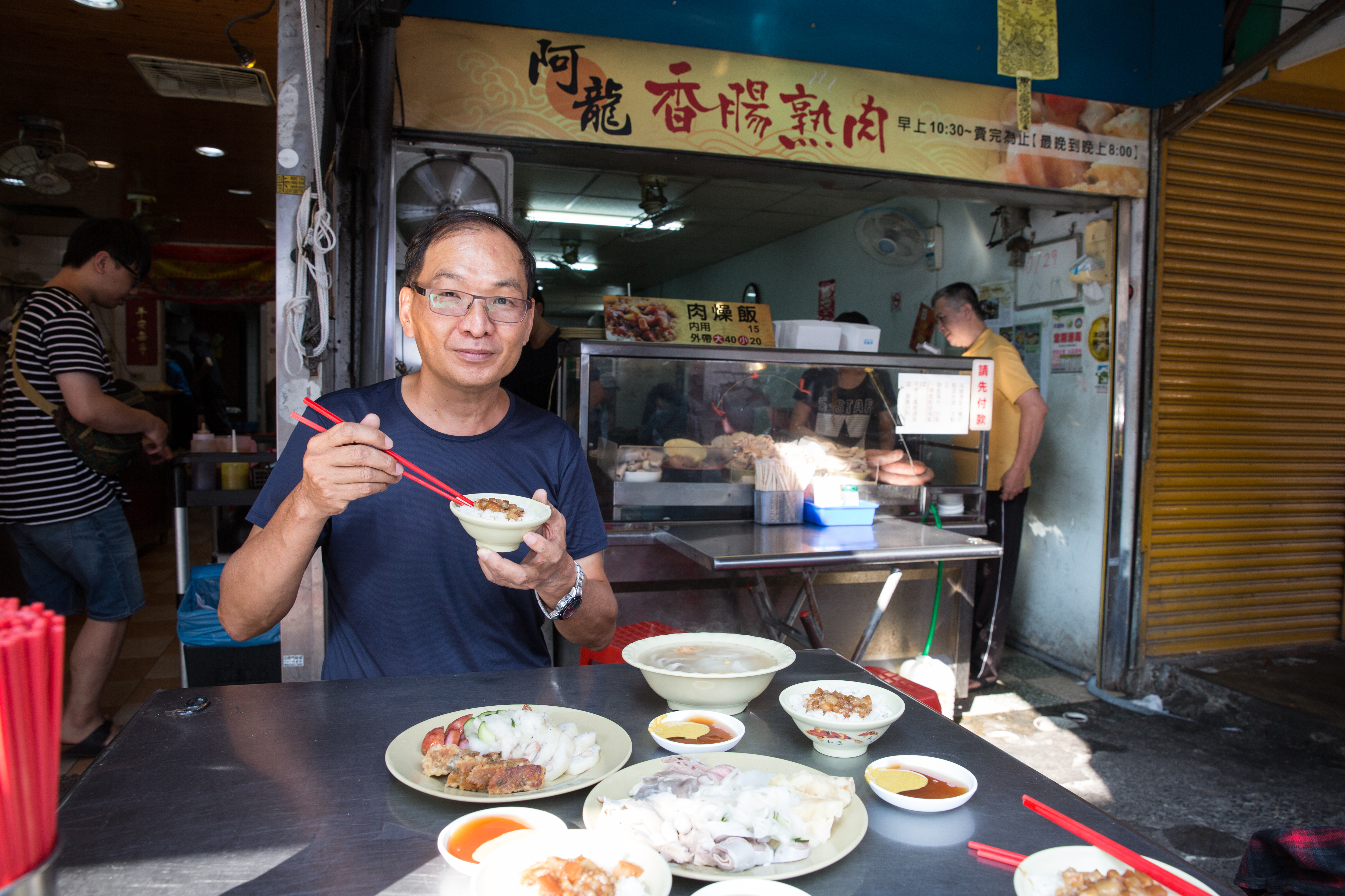 品嚐南部特有的香腸熟肉，是剪黏大師葉明吉工作之餘的小確幸。