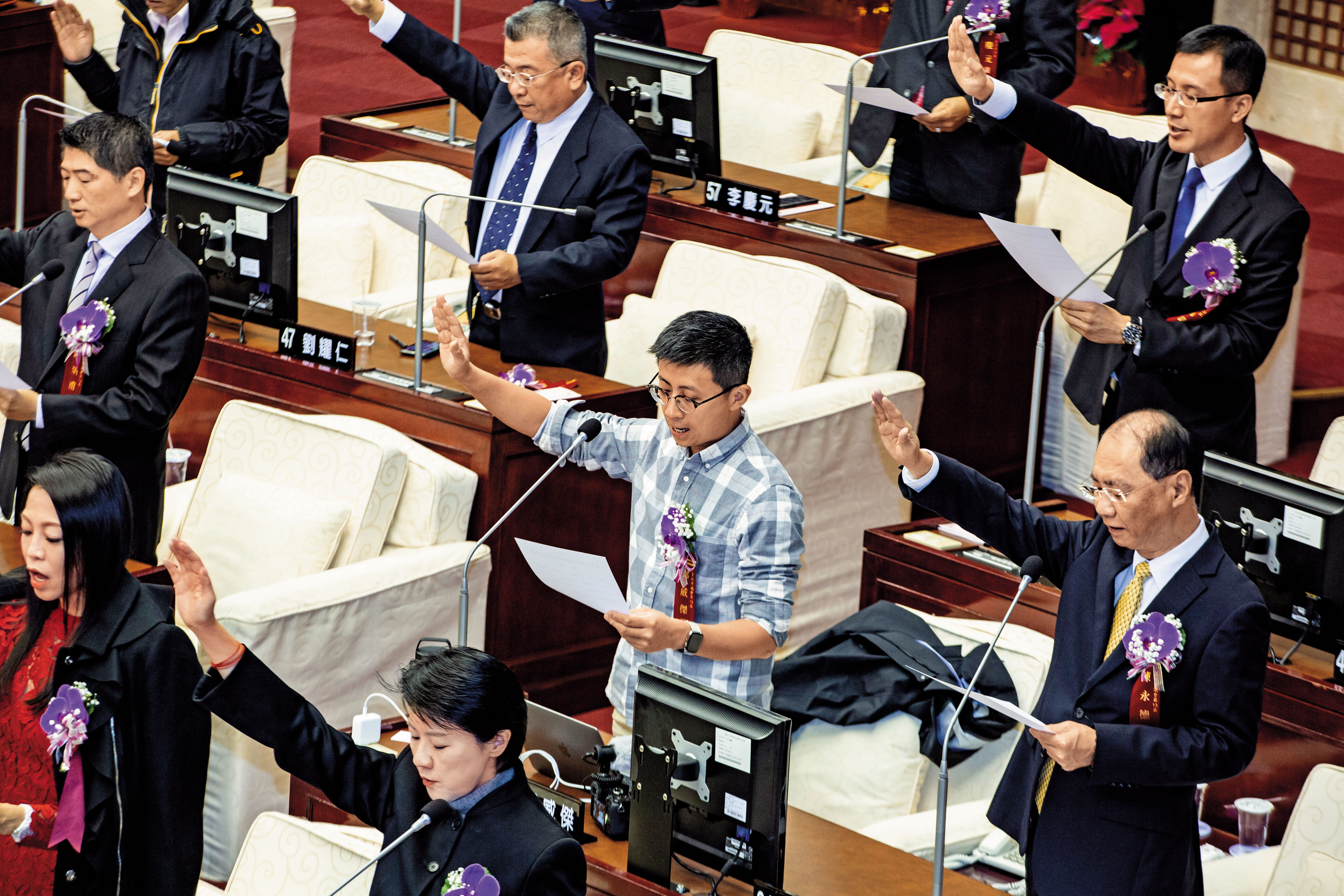 呱吉12月25日穿著襯衫卡其褲宣誓就職，形象與身旁的新科市議員大相逕庭。（王漢順攝）