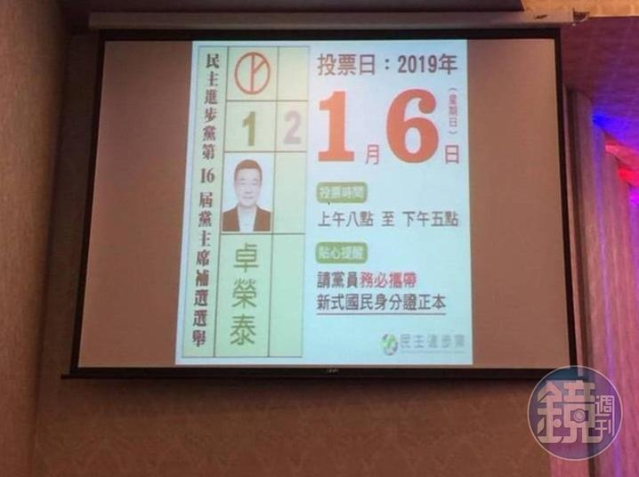 民進黨老黨員拍下餐會中螢幕上秀出替卓榮泰拉票的畫面訊息。(讀者提供)
