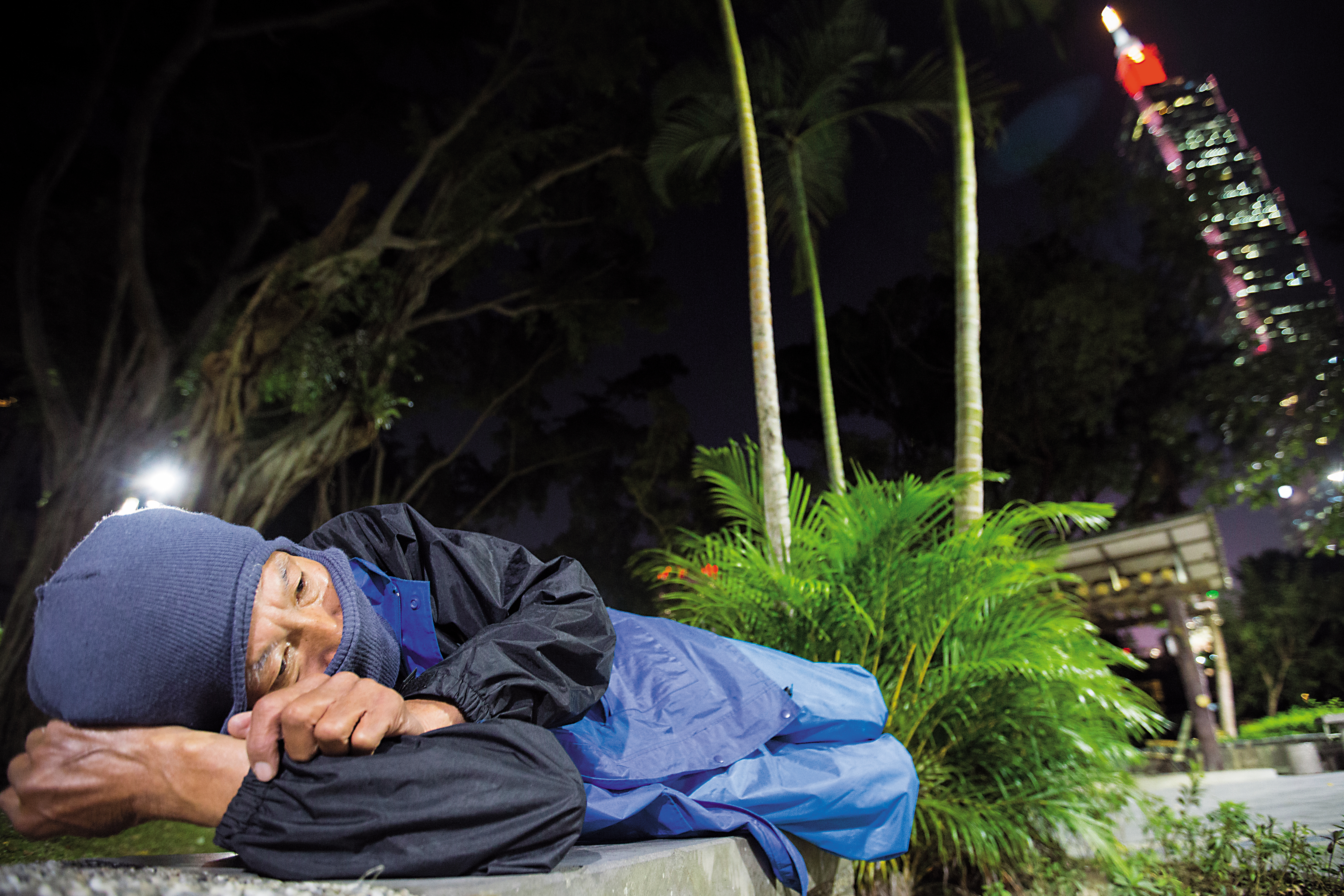 為防蚊蟲，謝天福穿著雨衣，頭罩毛帽，全副武裝睡覺。