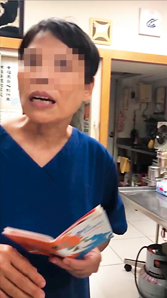 身穿藍衣拿著狗狗健康護照為寵物進行檢診的是「無照女獸醫」林美玲。（讀者提供）