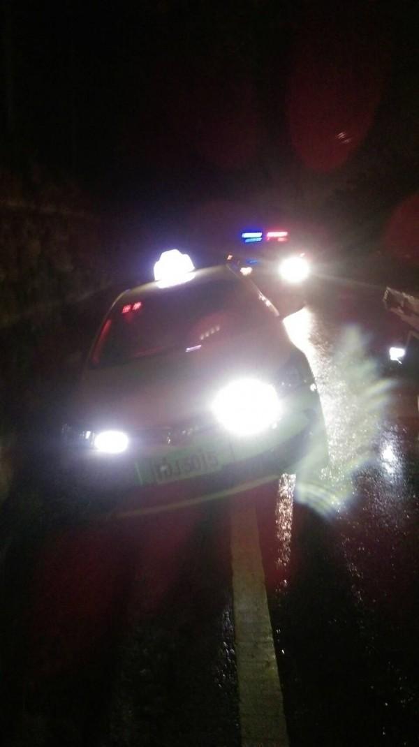 遭搶的計程車見警方圍捕，倒車時不慎卡在水溝內。（警方提供）