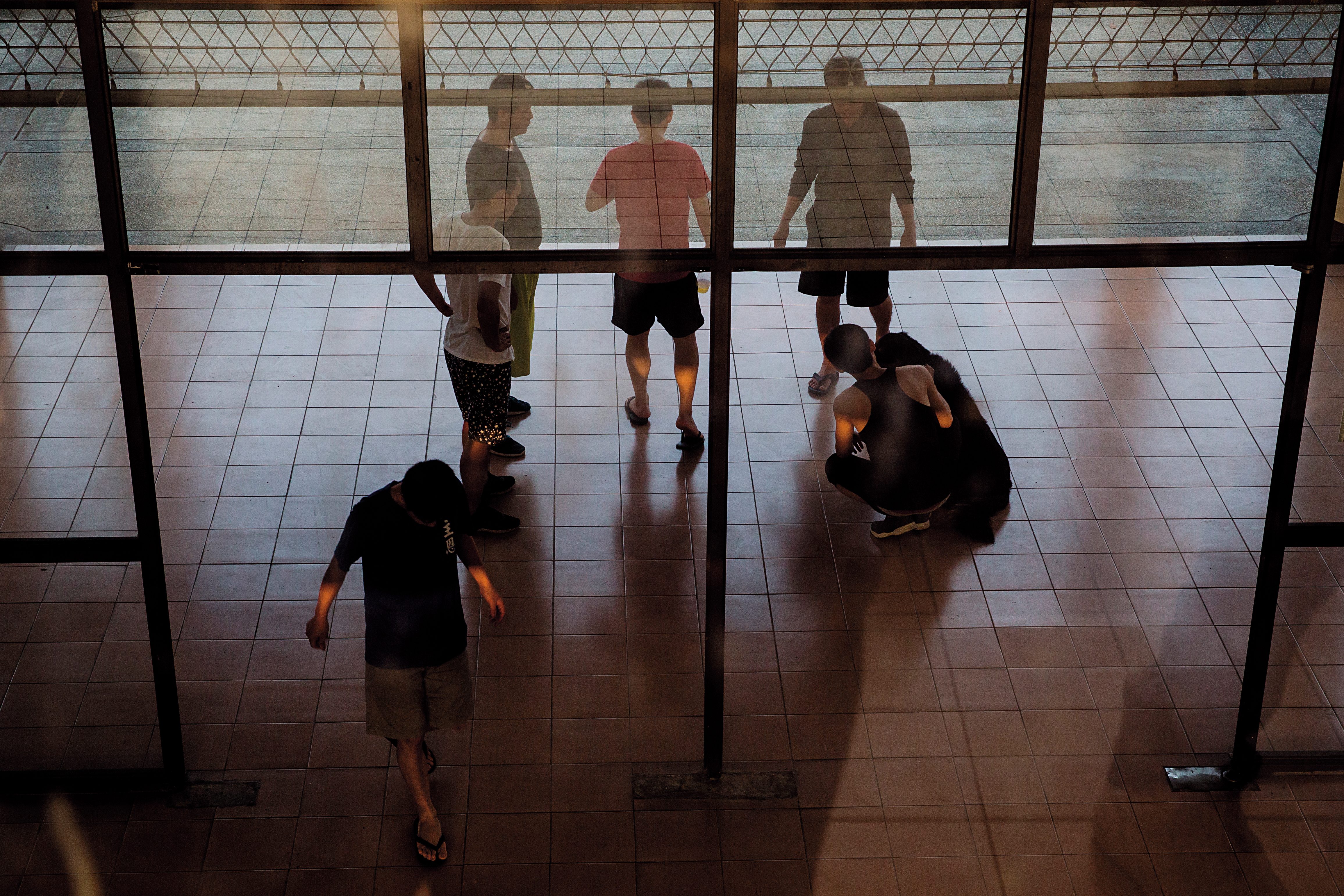 在晨曦會屏東戒毒村，除了課餘時間的自由活動，戒毒者必須按表操課。圖為戒毒者群聚聊天、逗弄小狗。