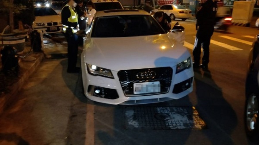 林女（車後白衣者）下體鼓起一大包，員警一度誤認是變裝的男人。