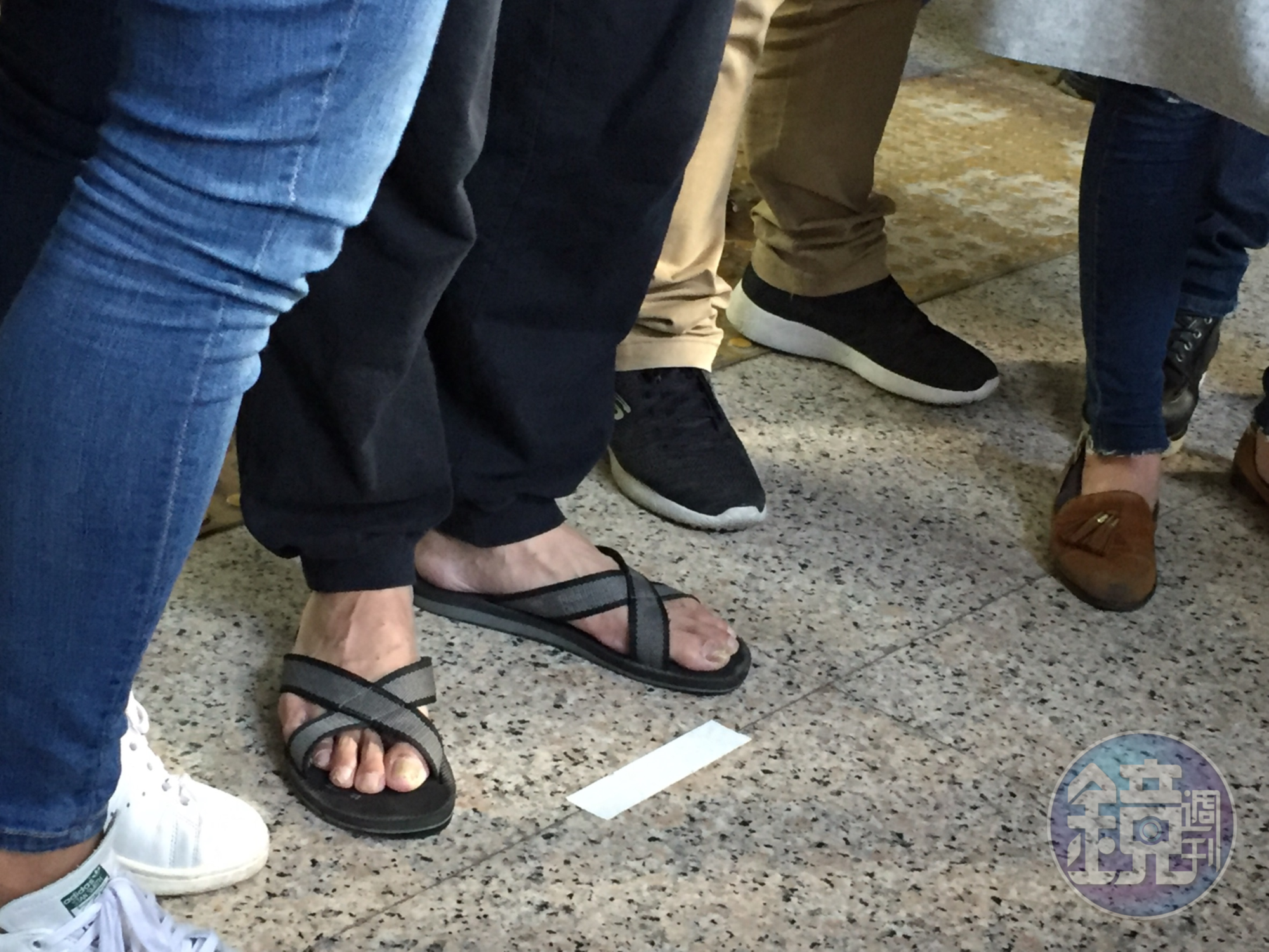 林男穿拖鞋、戴口罩,在警方保護下出面。