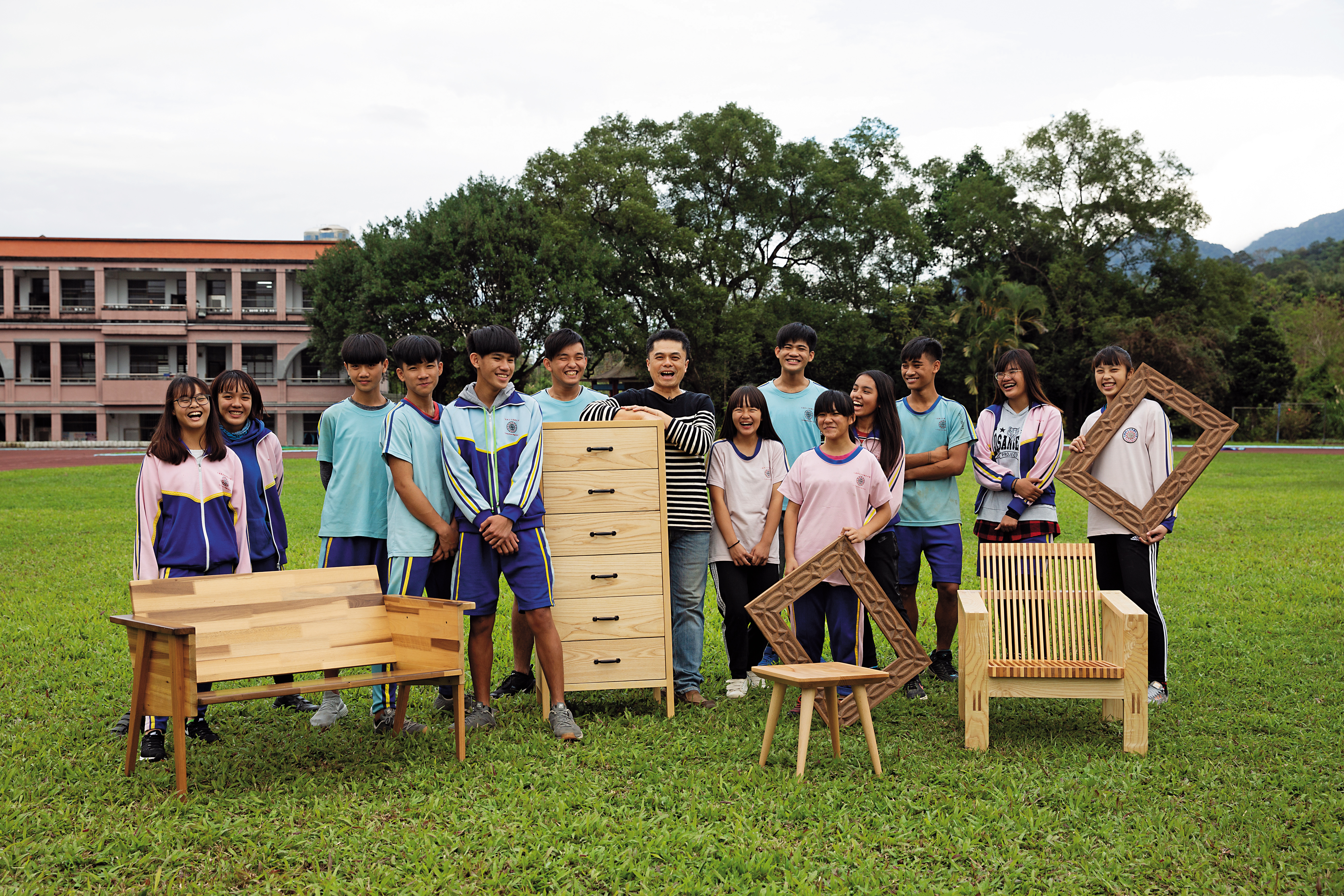 王嘉納（左7）與「玉東卡本特」木工班學生拍下合照，學生常暱稱他「爸爸」，他們像是一個大家庭。