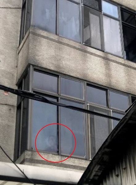 移工站在2樓窗口求援。(新北市勞工局提供)