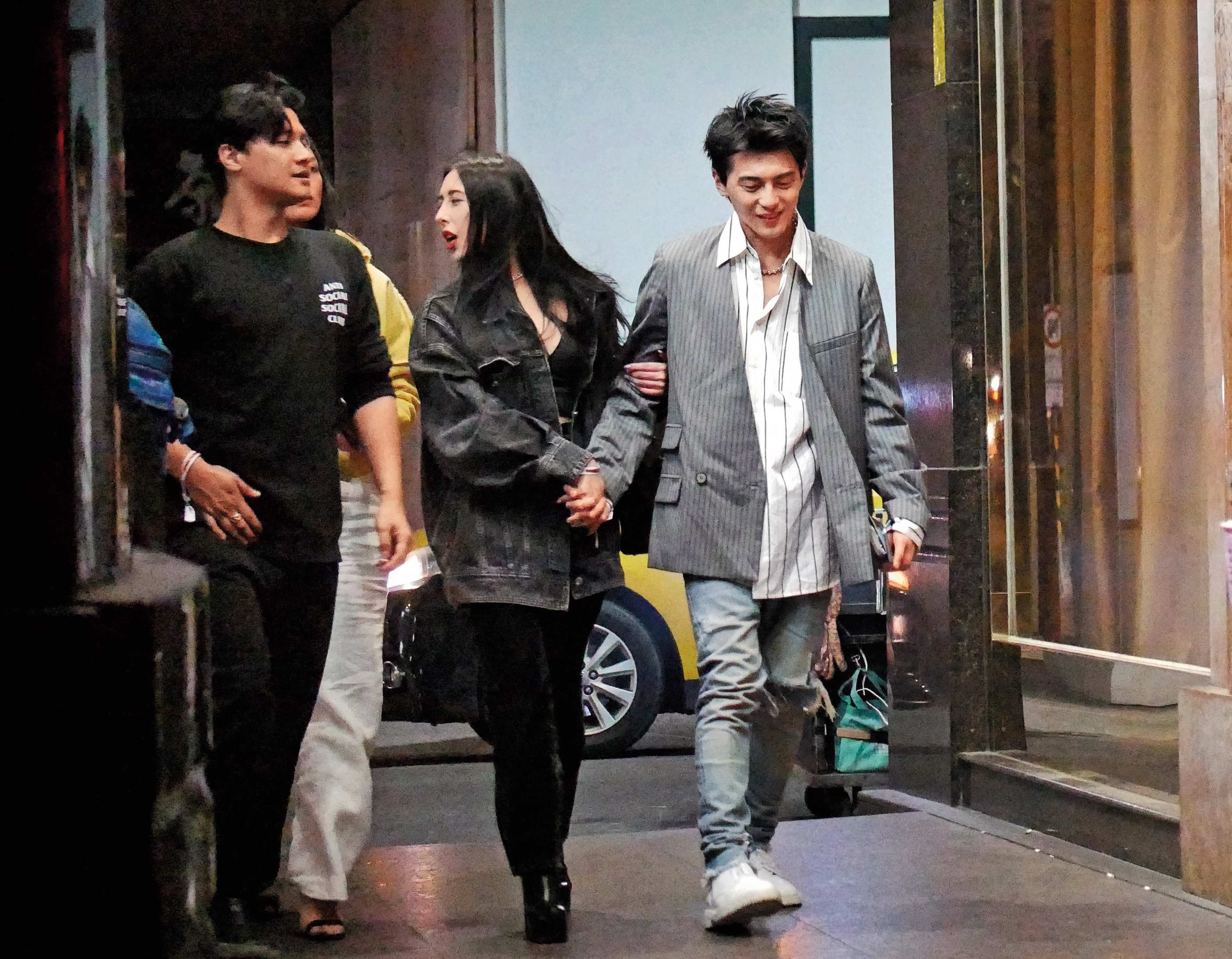 1月18日02：45，程穎婕（中）攬著謝睿宸（右）的手，和友人前往錢櫃續攤，她雖轉頭聊天，雙手仍緊牽著謝。