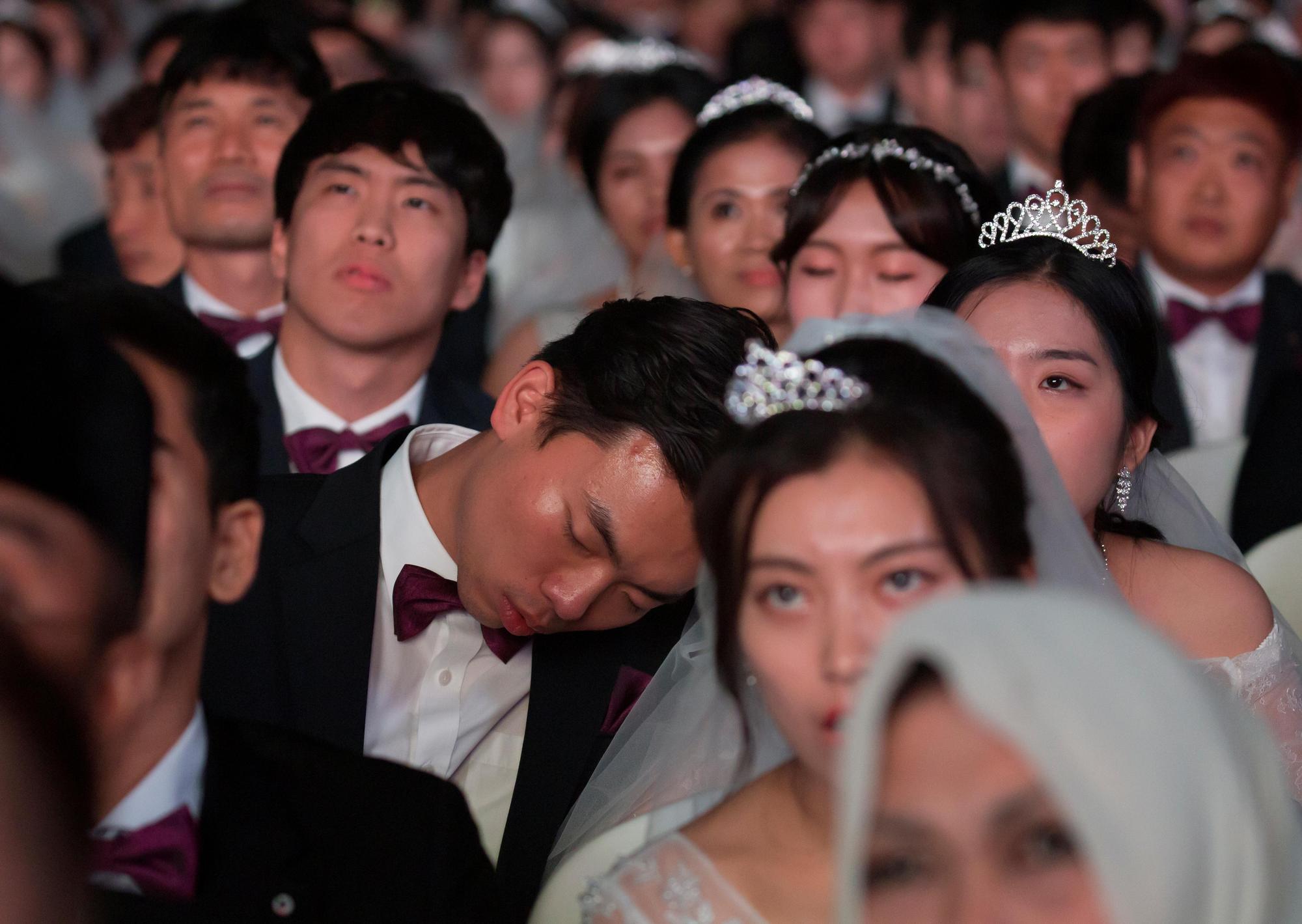 2018年8月27日，南韓加平郡清心和平世界中心的集團婚禮上，一名新郎在典禮中忍不住打起瞌睡。（東方IC）