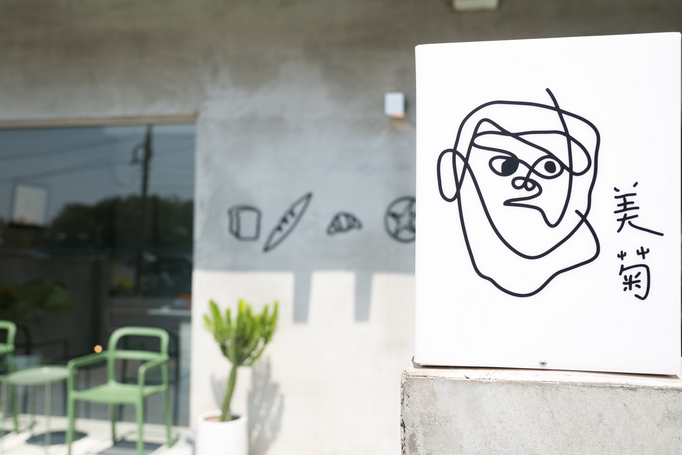 簡單白色招牌上只有人像和「美菊」兩字，讓人倍感好奇。