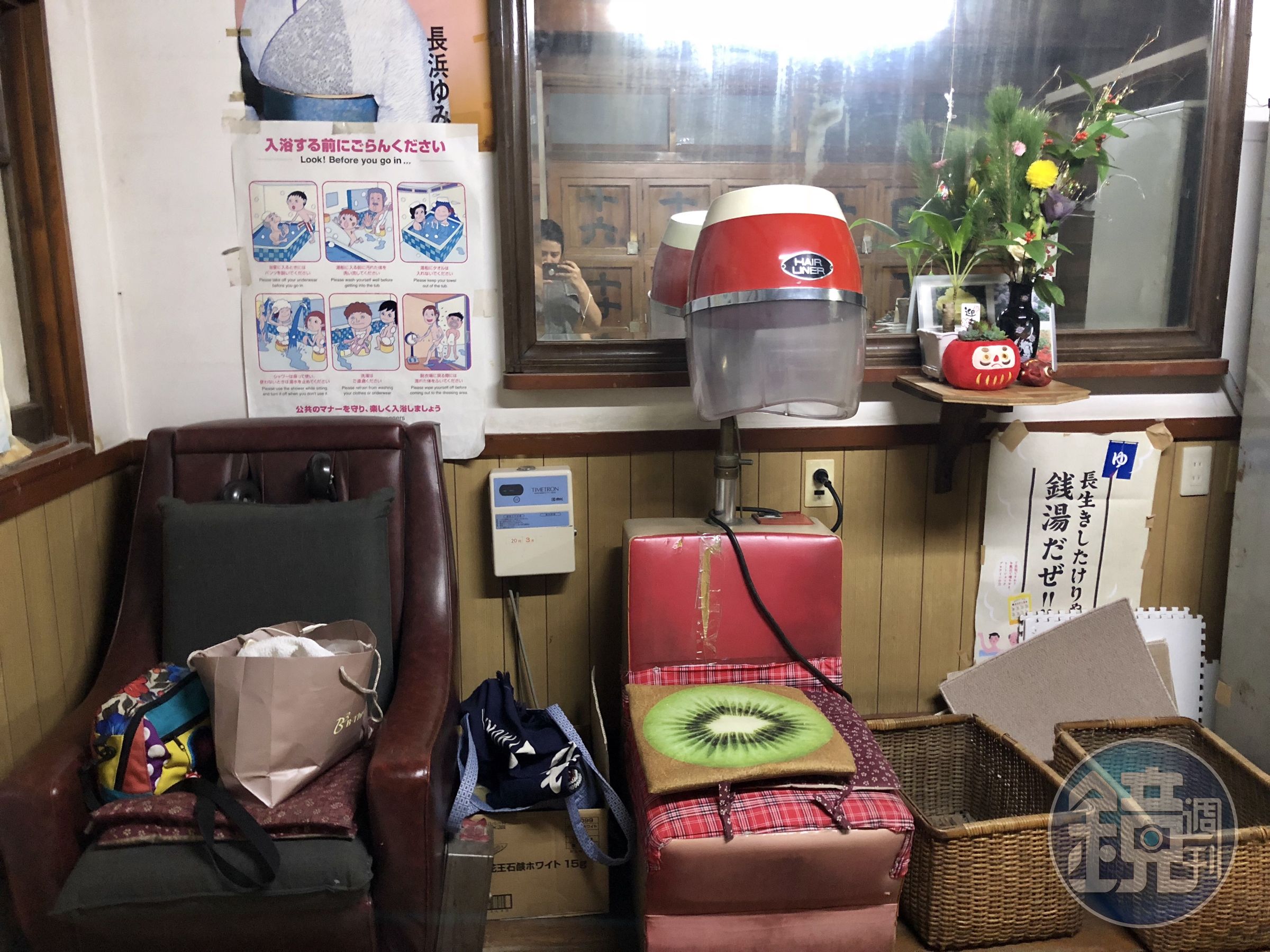 烘頭機器還可以使用，旁邊是已經故障的按摩椅。上面還放個奇異果花紋的椅墊。