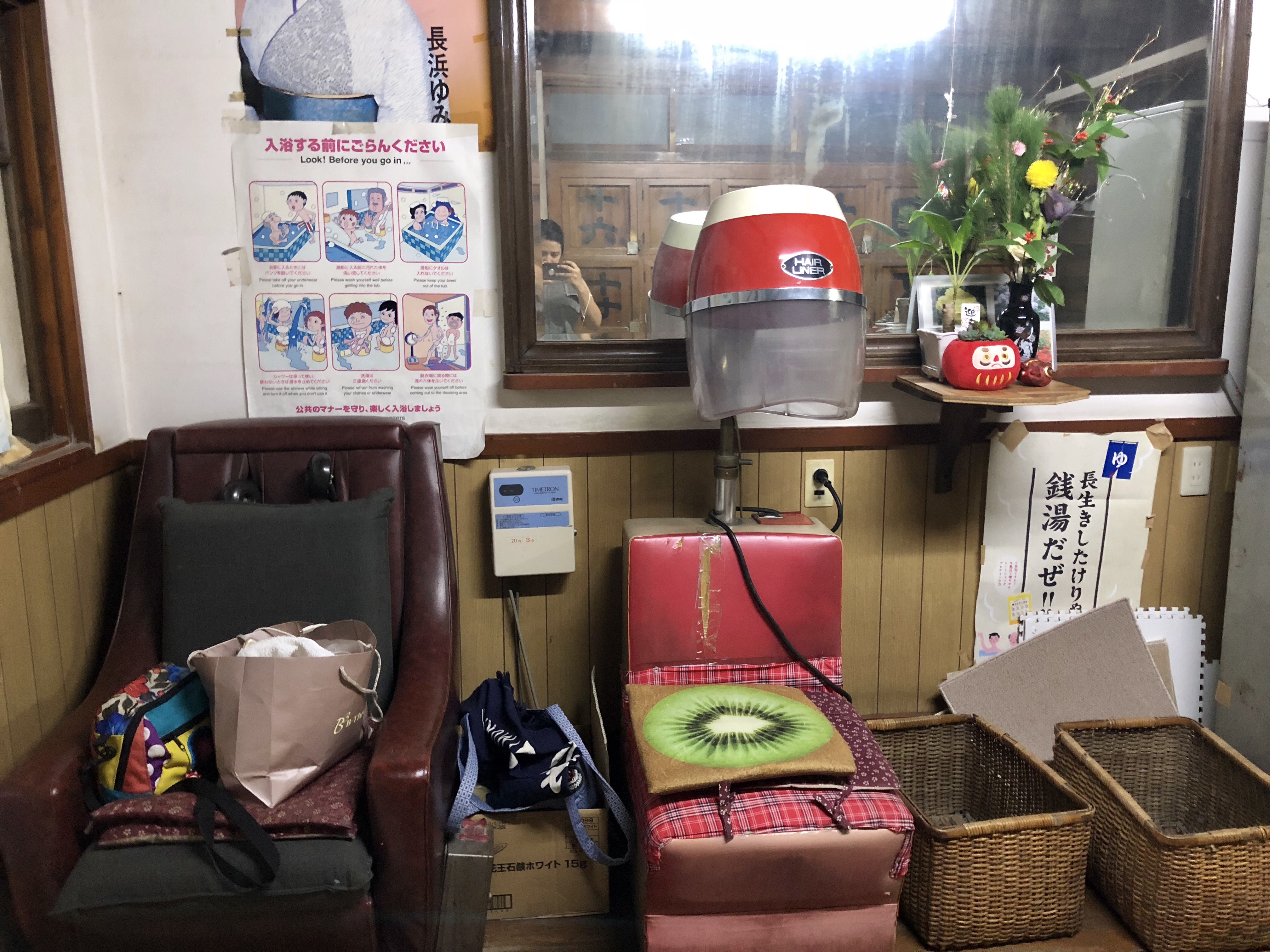 烘頭機器還可以使用，旁邊是已經故障的按摩椅。上面還放個奇異果花紋的椅墊。