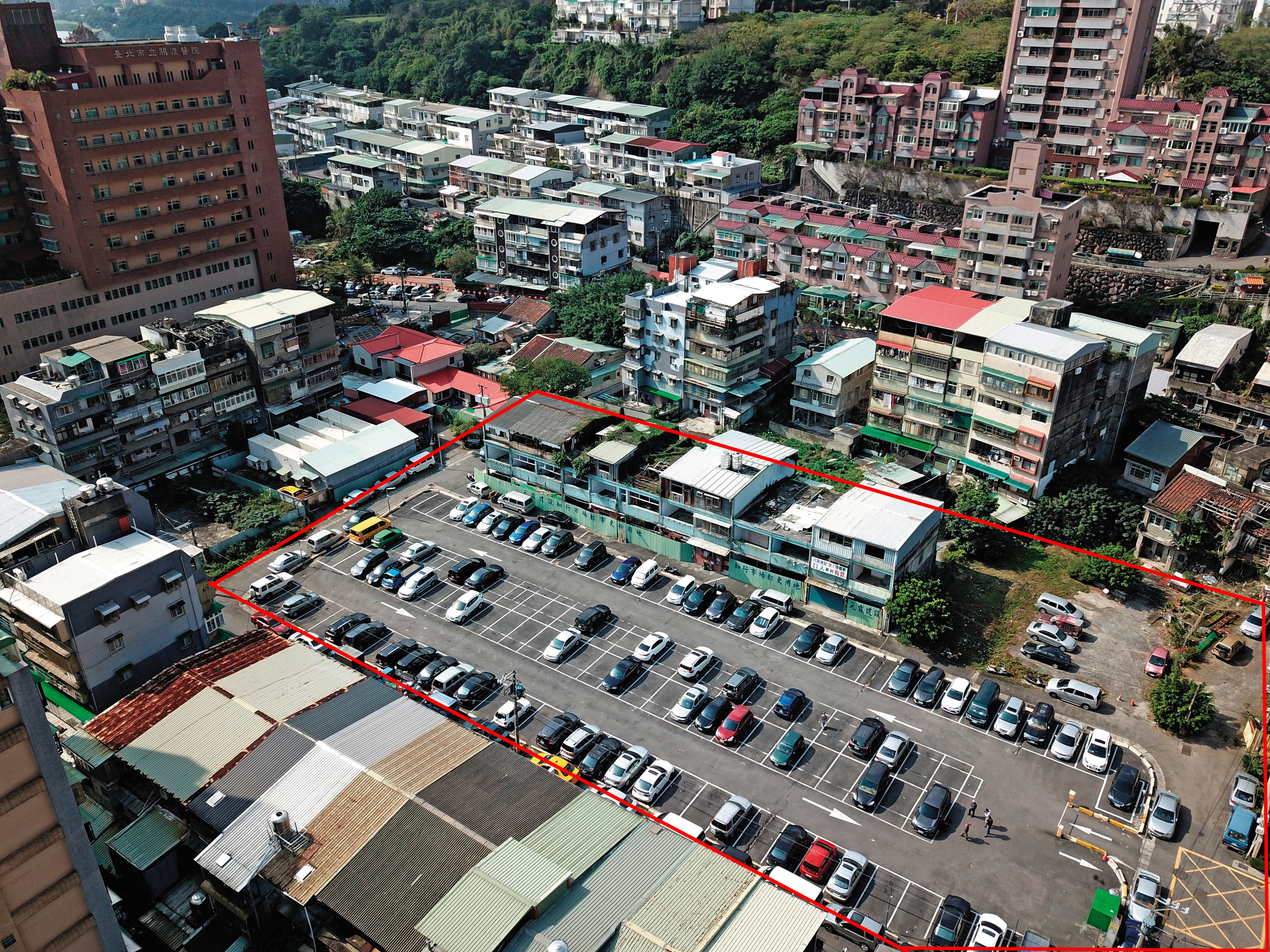 台北市關渡知行路都更案總面積約1,500坪（紅框處），緊鄰關渡醫院，因爆發灌人頭弊端，目前停擺中，大部分土地暫時闢為停車場。