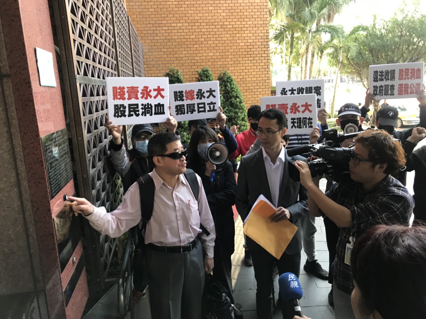 永大公司小股東黃文泰（戴墨鏡者）與十多位股民到台北地檢署按鈴告發永大6名董事。