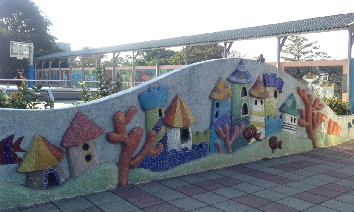 東安國小操場旁的矮牆是波浪形，牆上有師生共同拼貼出的馬賽克立體圖案。