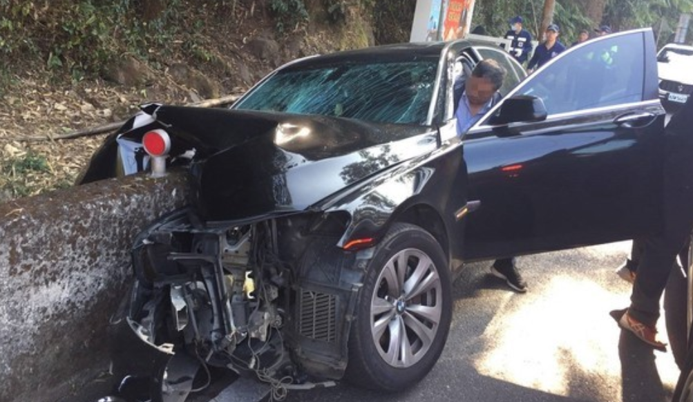 一輛BMW大7疑因路況不熟，車頭撞擊水泥牆被剖半。（翻攝畫面）