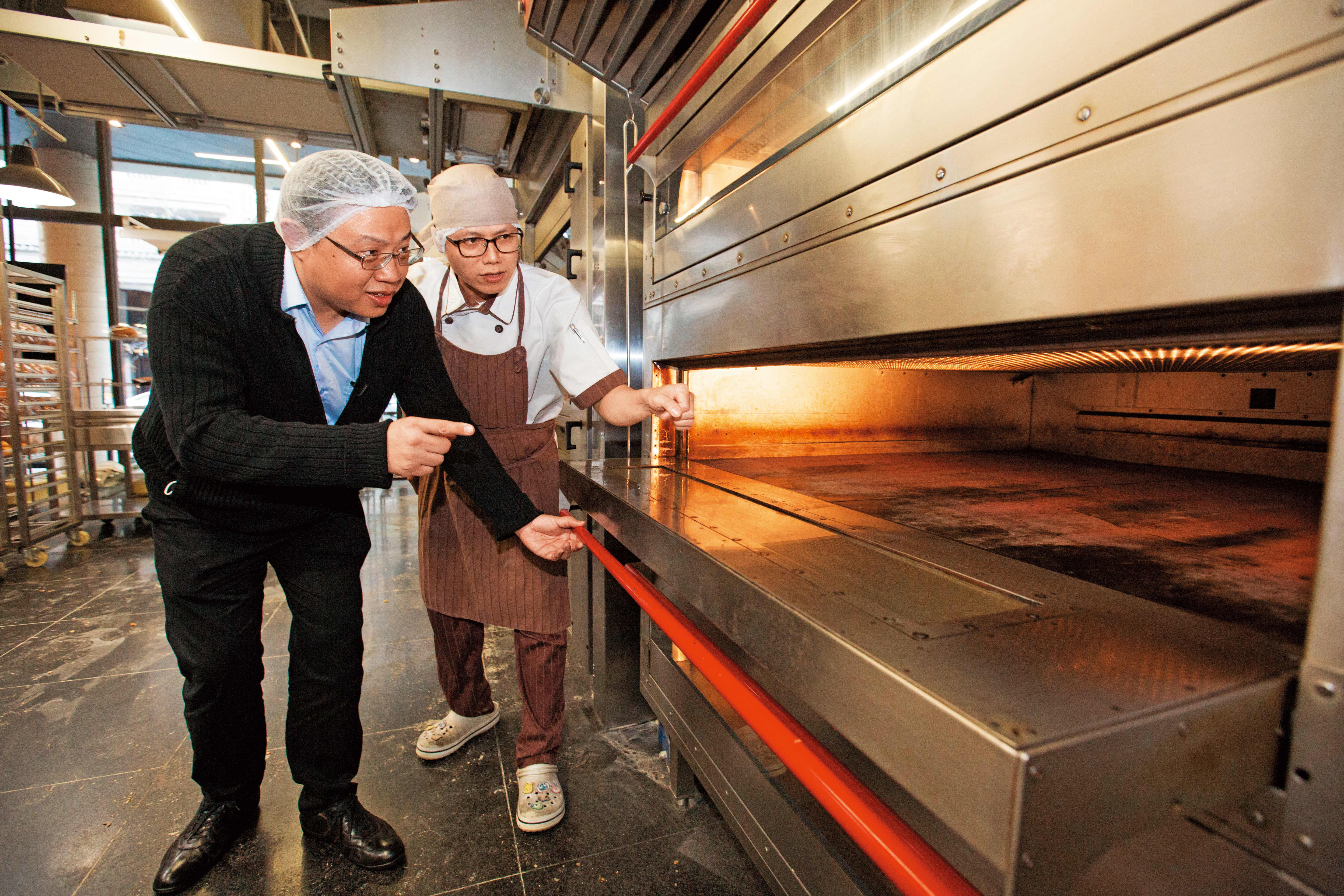 許多烘焙名店如吳寶春店都是使用中部電機烤箱，黃正仲（左）會到店家檢查、維修設備。