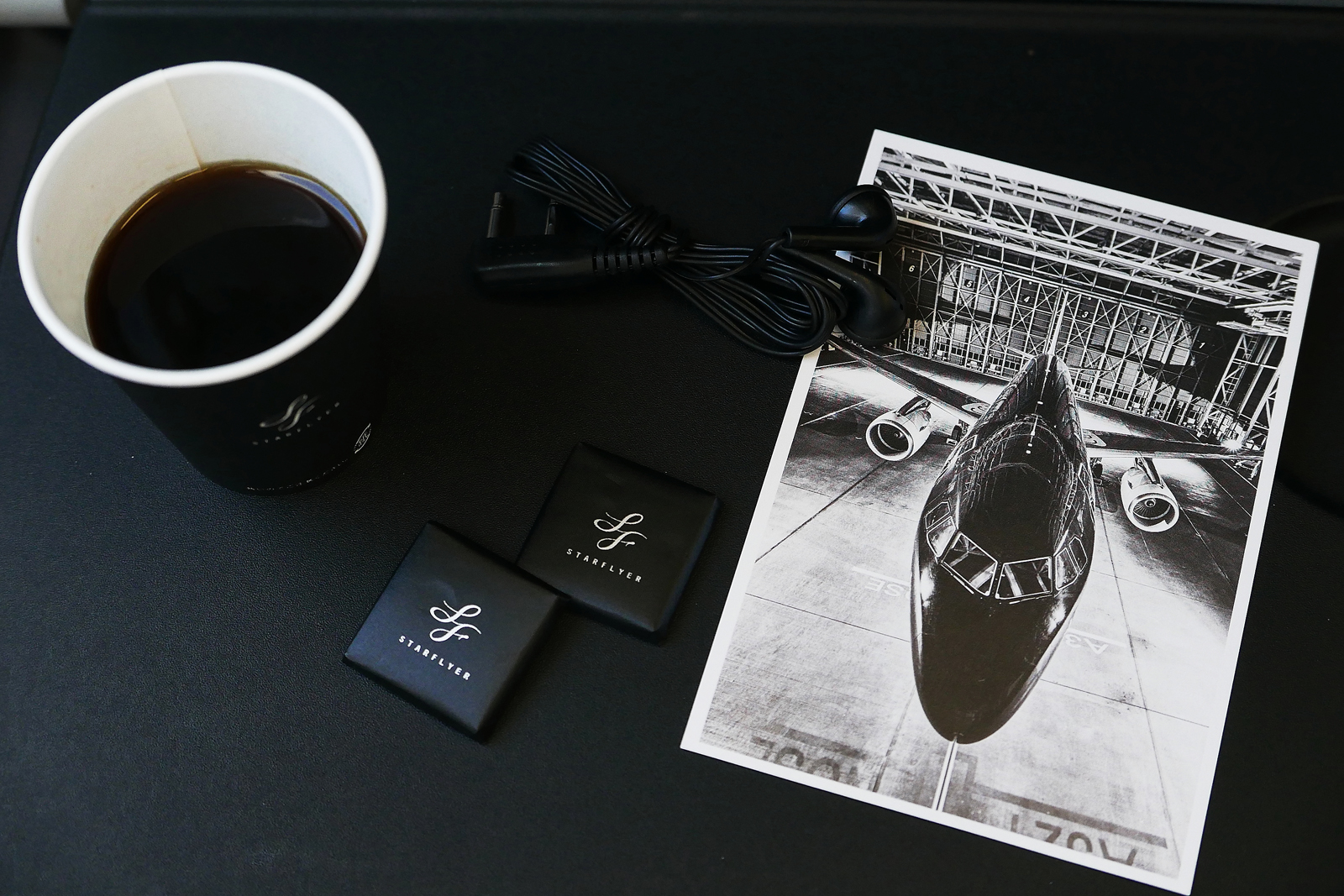 星悅航空善用黑白配色，設計出許多貼心服務，像是明信片、紙杯與小糖果。