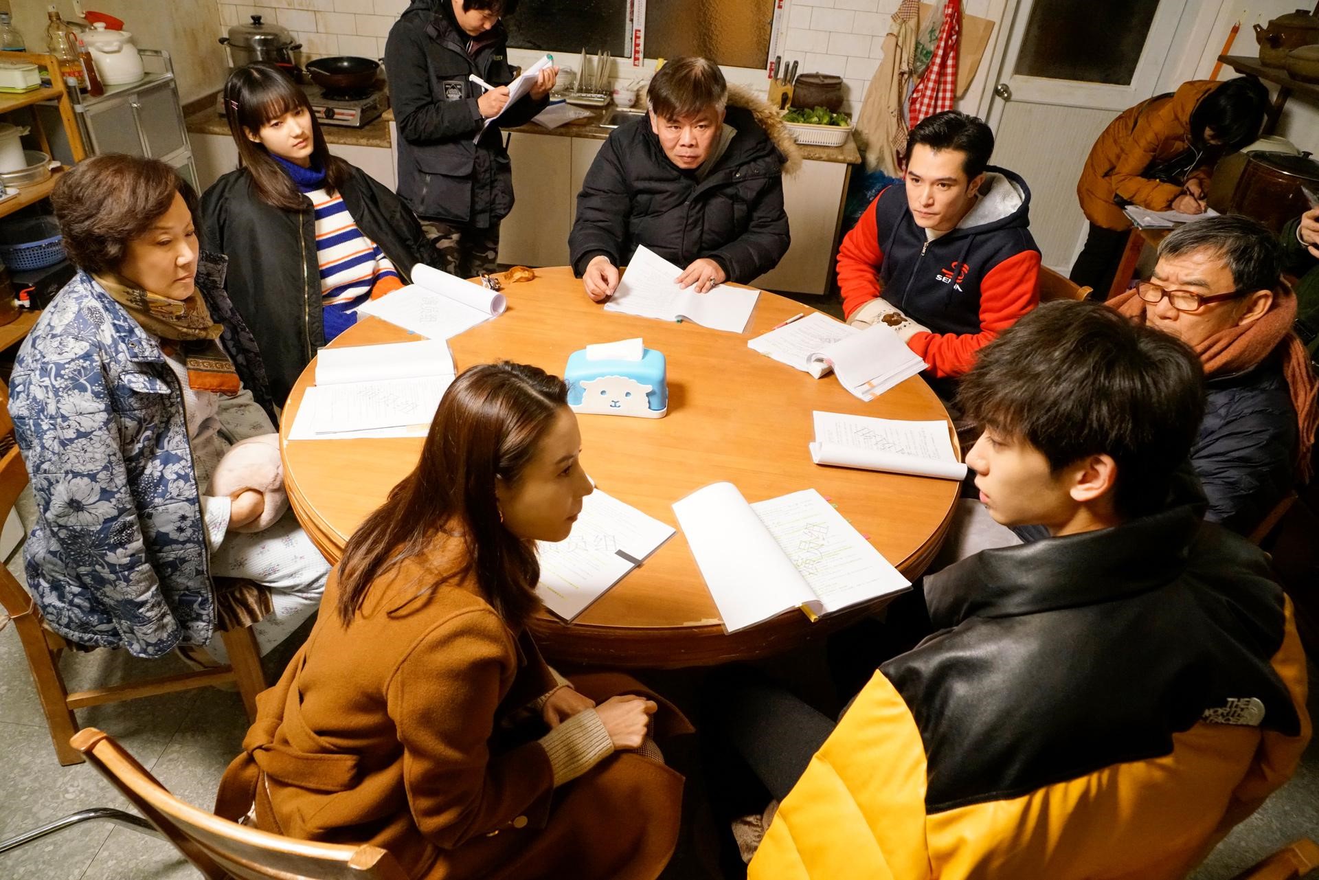 《幸福一家人》導演馮凱（中）及演員群聚，在劇組搭建的客廳場景內讀本。（恩喬依提供）