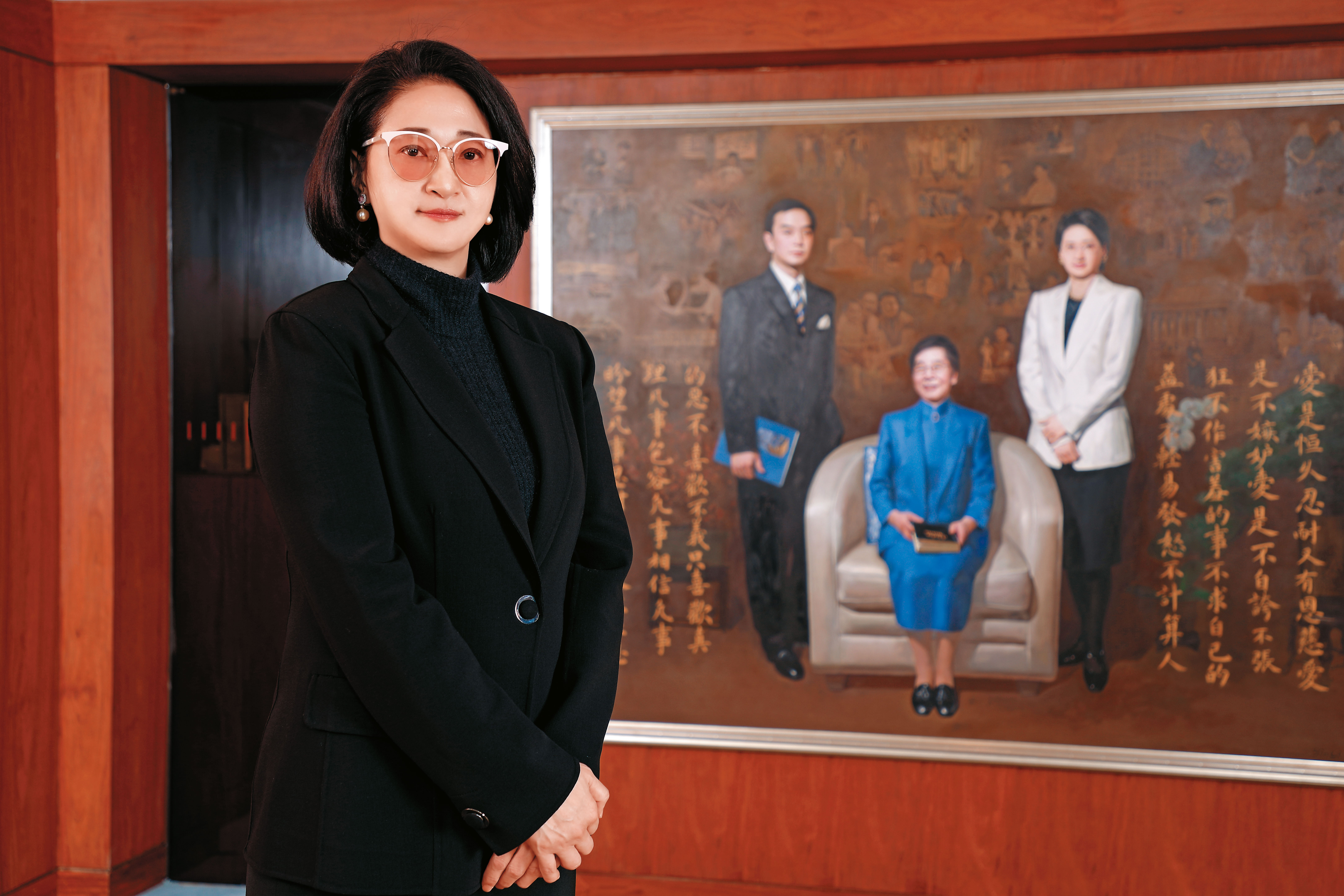 站在與婆婆吳舜文、夫婿嚴凱泰畫像前，嚴陳莉蓮要繼續圓「國車國造」夢想。（裕隆提供）