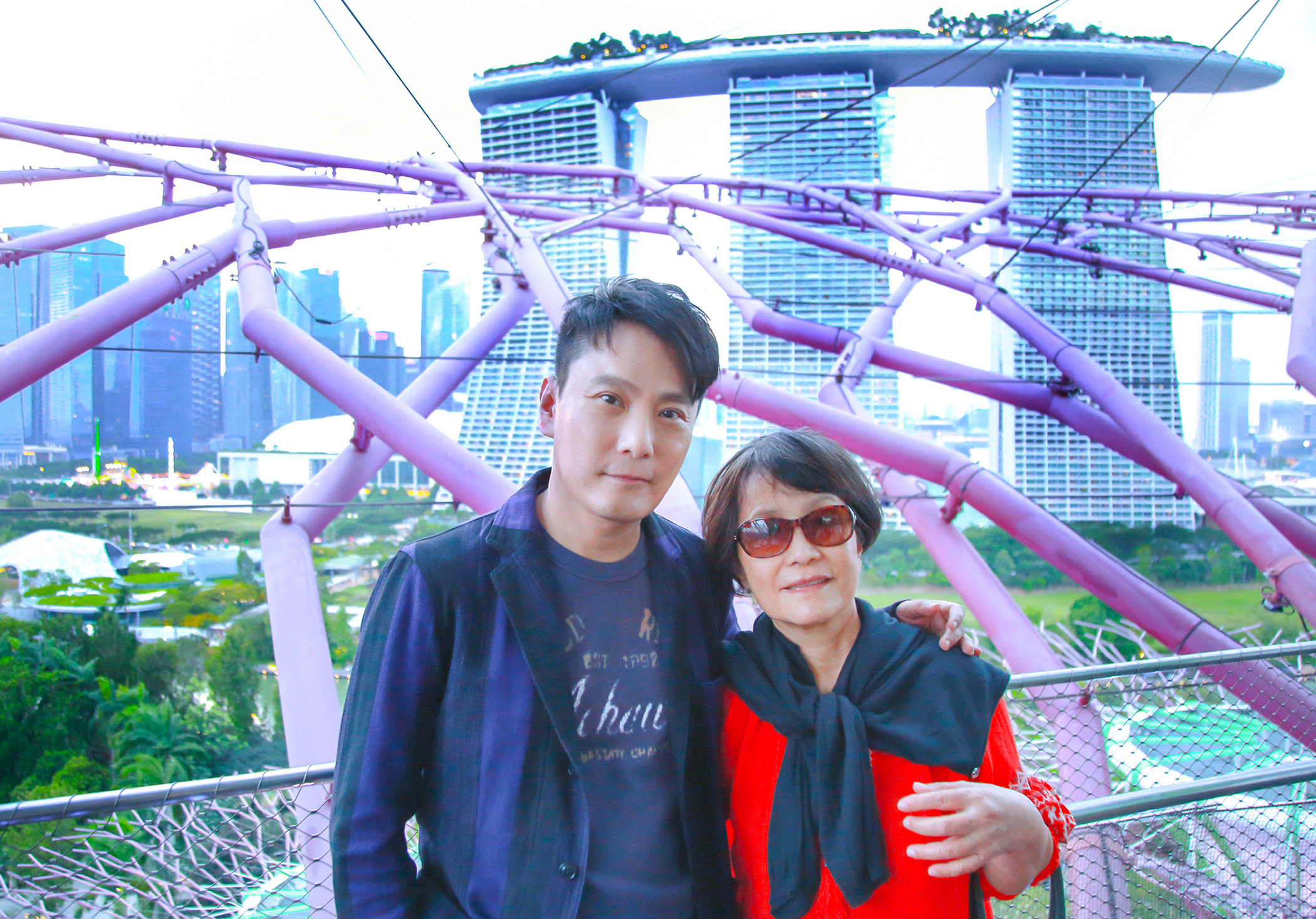 張信哲一家飽覽新加坡美景，他攬著「前世情人媽媽」合照。 （潮水音樂提供）