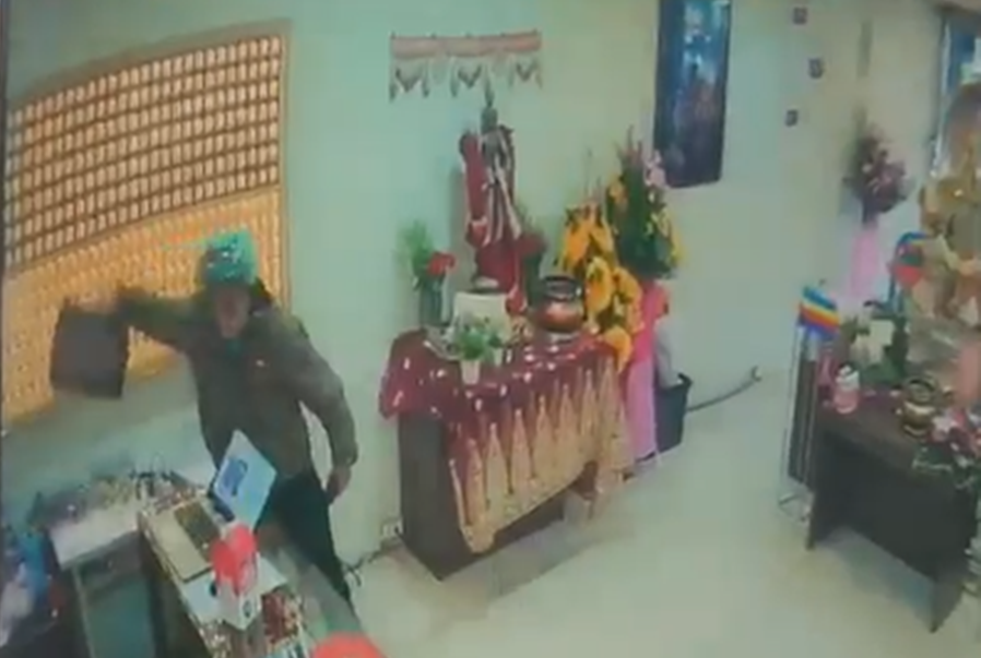 竊賊見吳女包包置於桌上，順手將包包偷走後從容離開。（翻攝畫面）