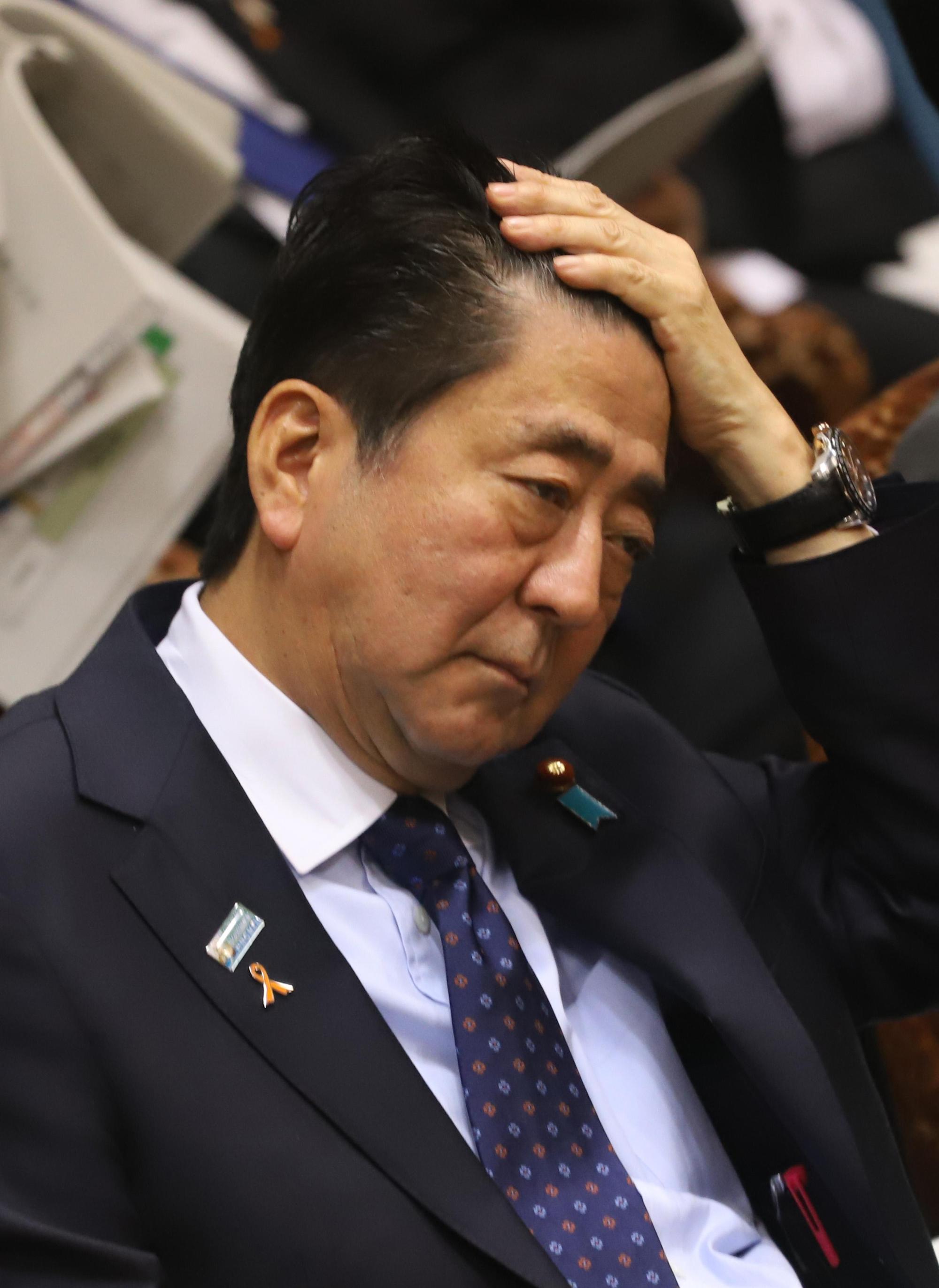 2018年11月5日，日本首相安倍出席參院預算審議，撫頭沈思無意間露出髮際線。（東方IC）