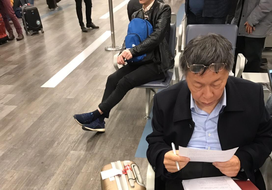 柯文哲這次出訪,被拍到在等機一直埋頭讀資料。(讀者提供)