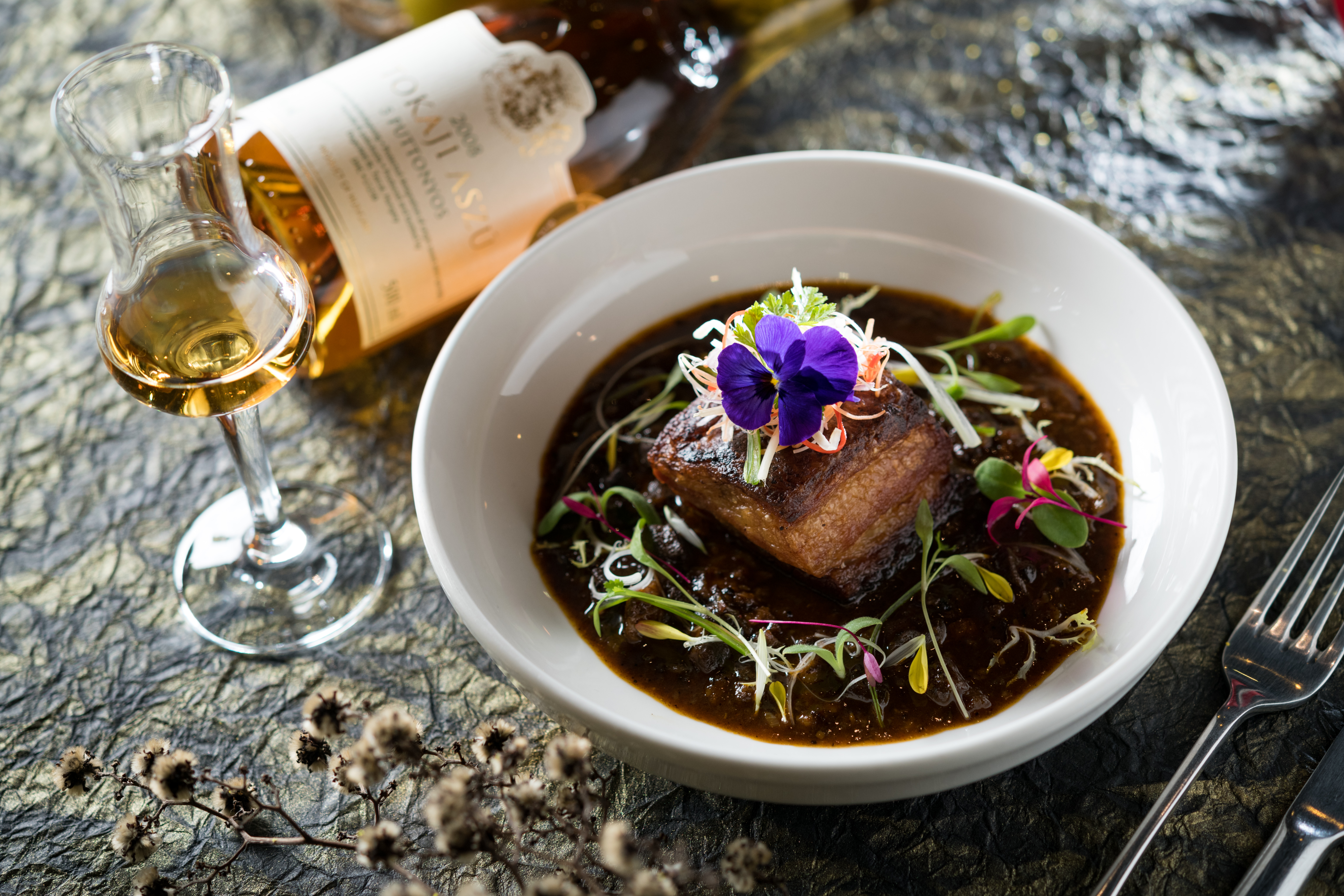 金黃色酒液的甜美貴腐酒，想不到與印度新派料理「脆皮豬五花咖哩」這麼搭。