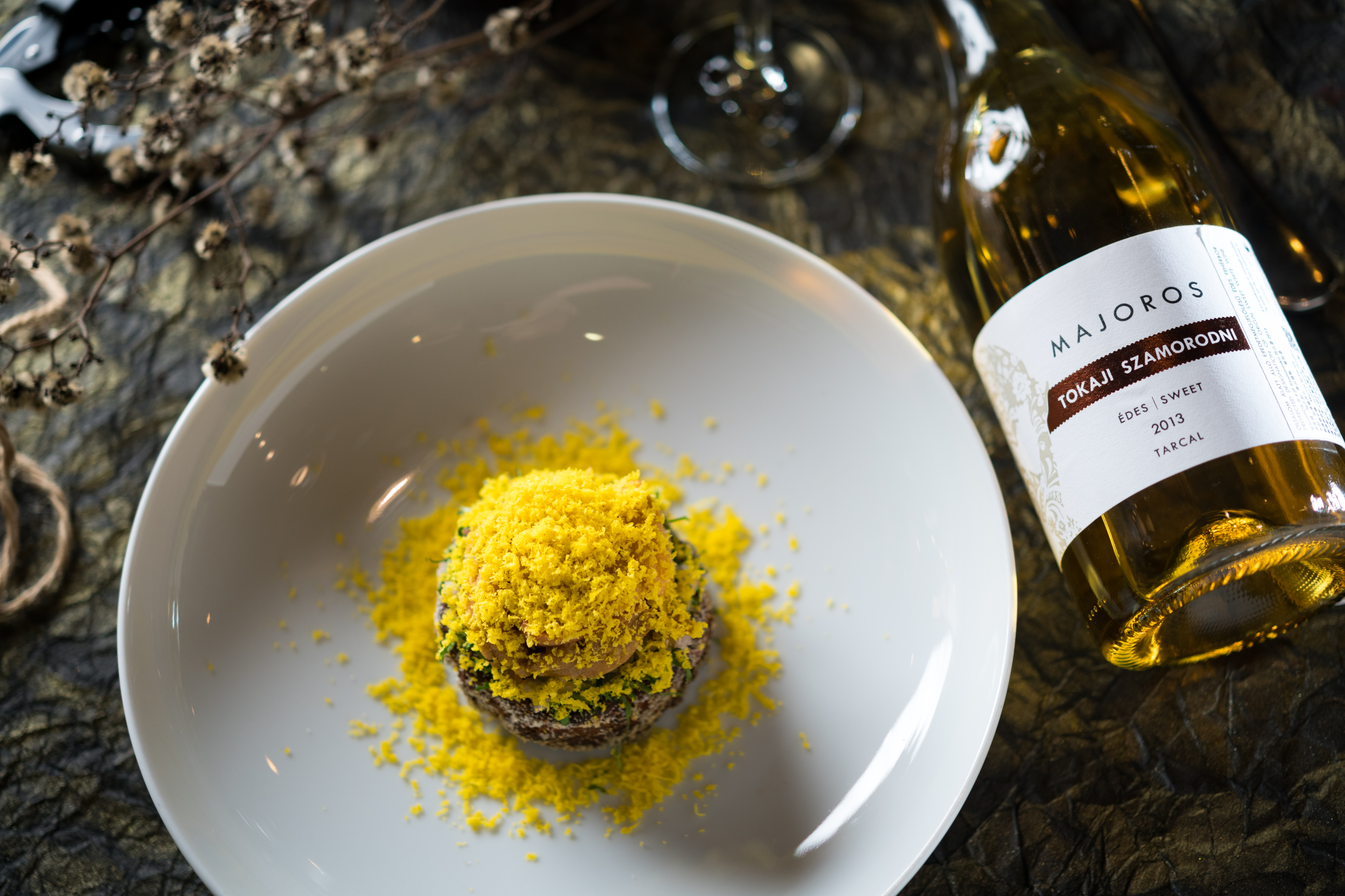 「莫若悠許 多卡伊Szamorodni甜白酒2013」（1,680元／瓶）有蜂蜜、柑橘香氣，配上「酥煎魚餅佐海膽嫩薑泥」，用檸檬香的油甘果搭起酒食橋梁。（580元／份）