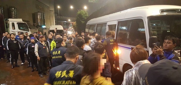 移民署將22名非法移工押送上車。(移民署提供)