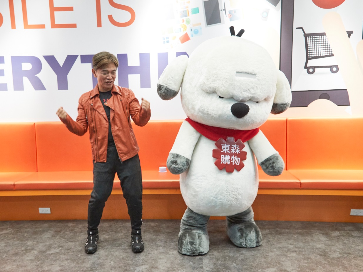 吳宗憲與東森吉祥物得意狗合影，還自誇自己腰力過人。（東森購物提供）