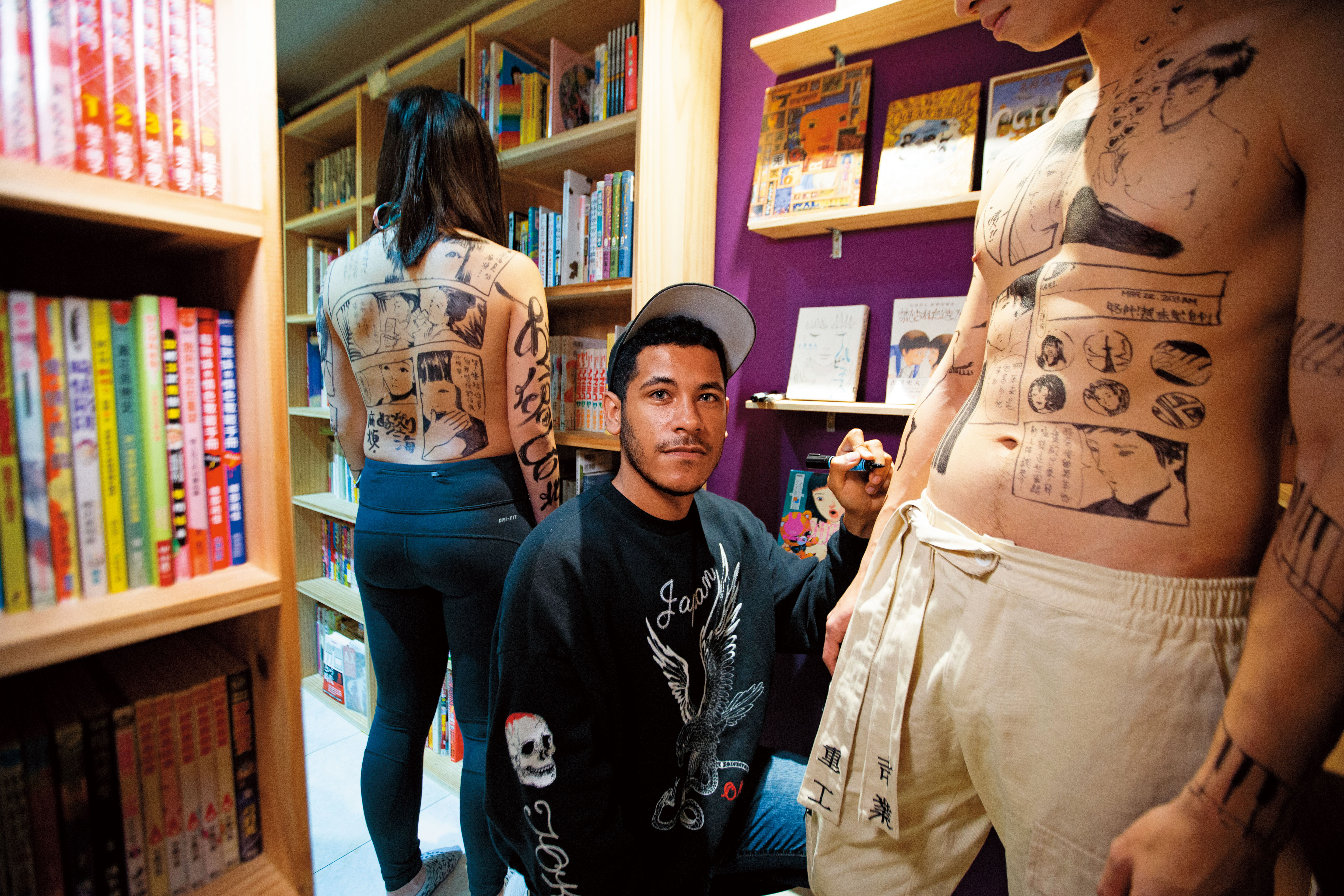 在人體畫漫畫挑戰不小,盧卡斯(中)每次都會先跟模特兒聊故事再下筆。這天他在男友Chris(右)身上畫的是二人相戀的故事。