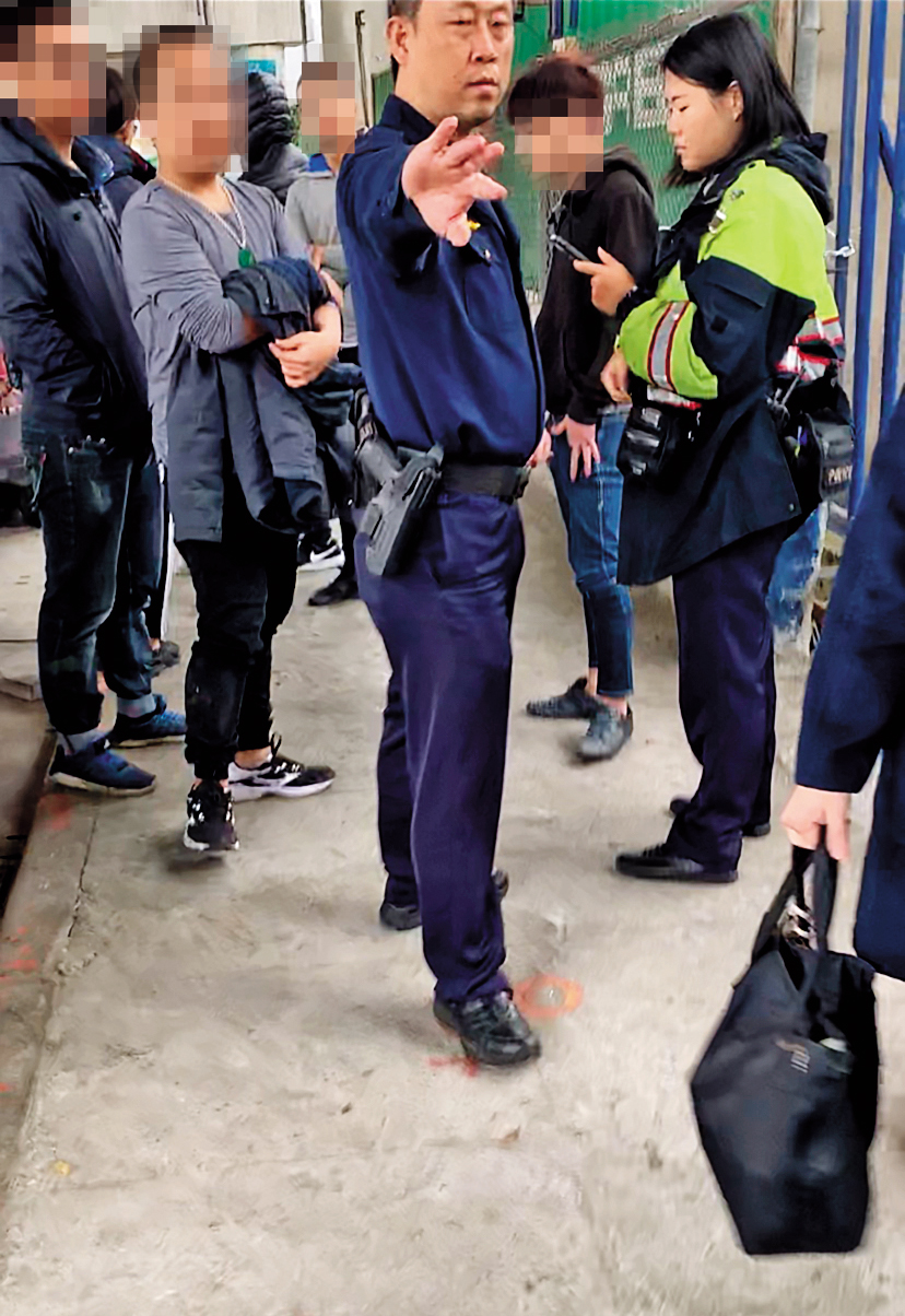 不明黑衣人士圍堵印北倉庫出入口，警方荷槍實彈不敢大意。（讀者提供）