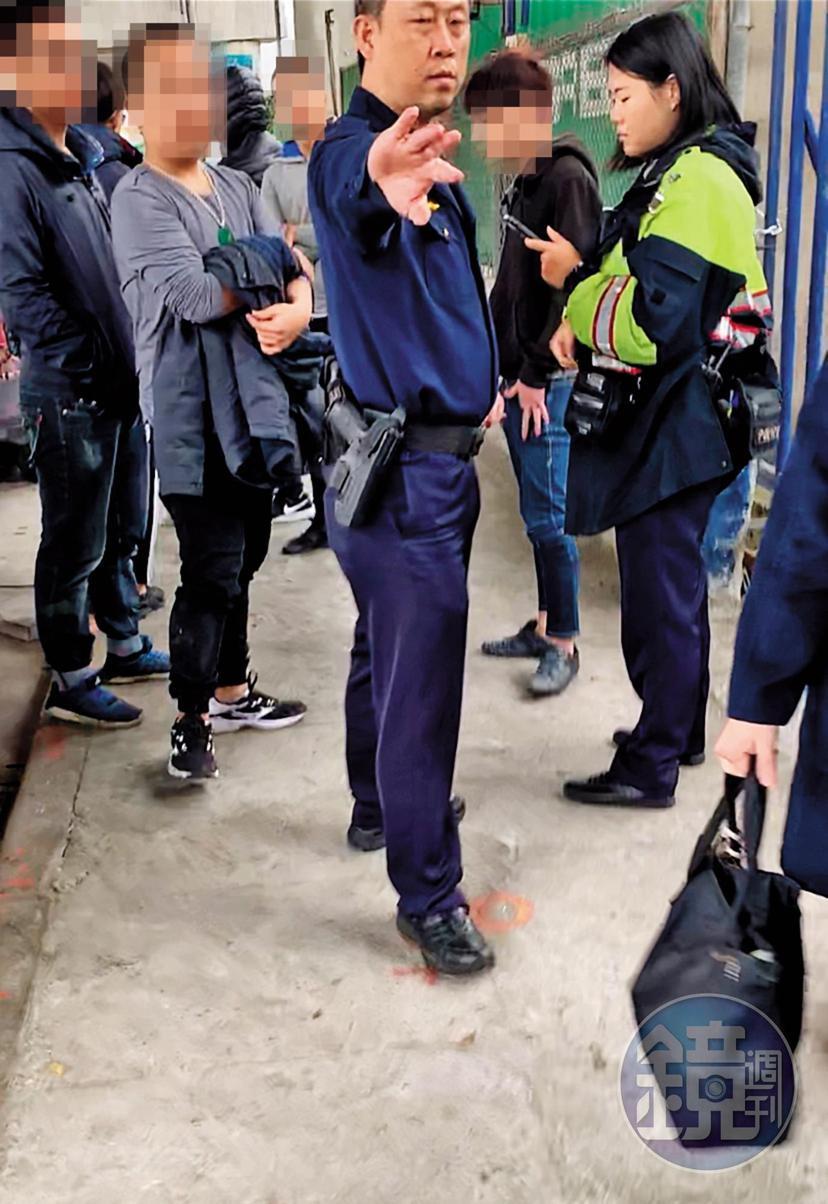 不明黑衣人士圍堵印北倉庫出入口，警方荷槍實彈不敢大意。（讀者提供）
