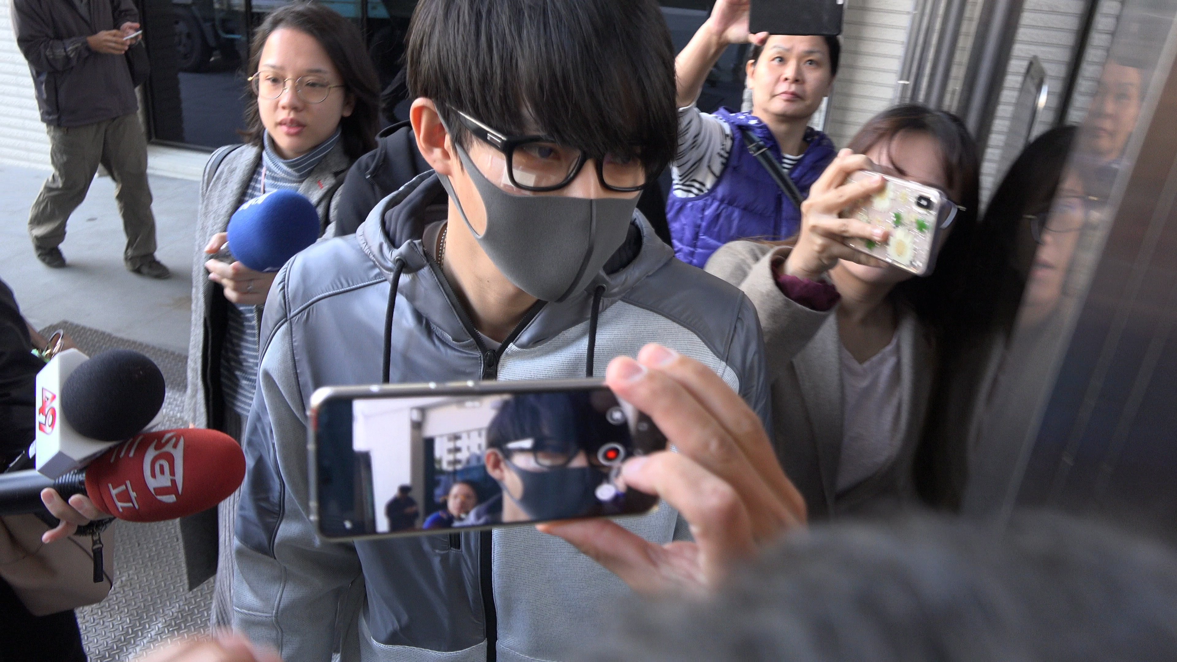 張庭瑚戴著口罩和經紀人現身士林地檢署。