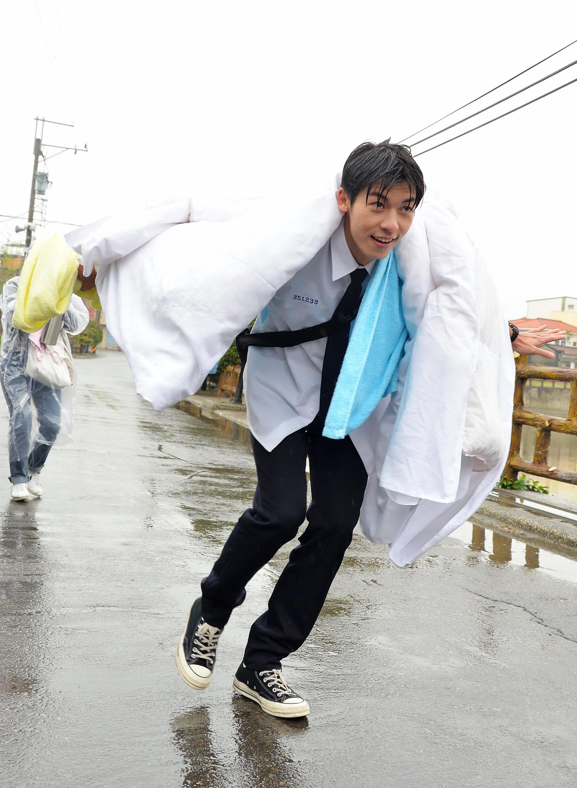 許光漢在大雨中披棉被走秀裝名模。（福斯傳媒集團提供）