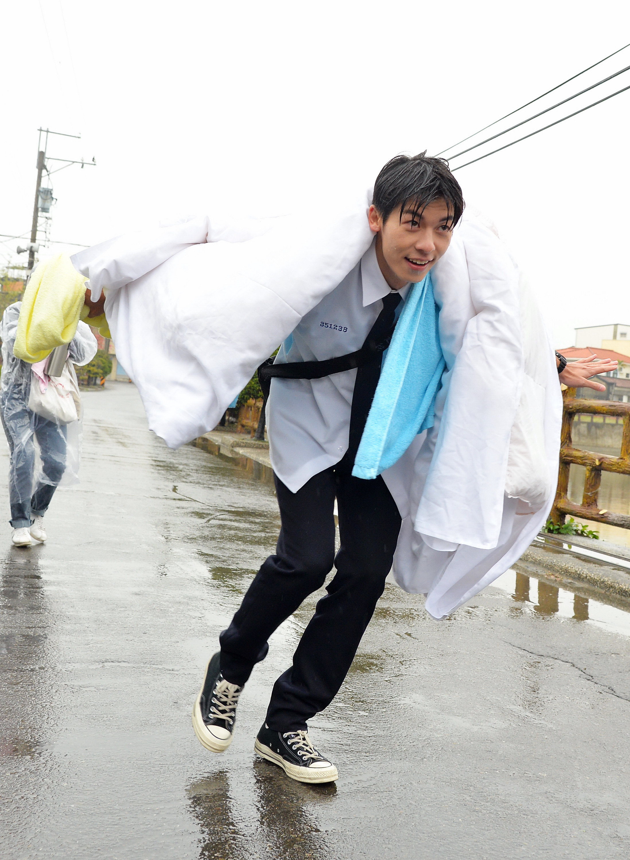 許光漢在大雨中披棉被走秀裝名模。（福斯傳媒集團提供）