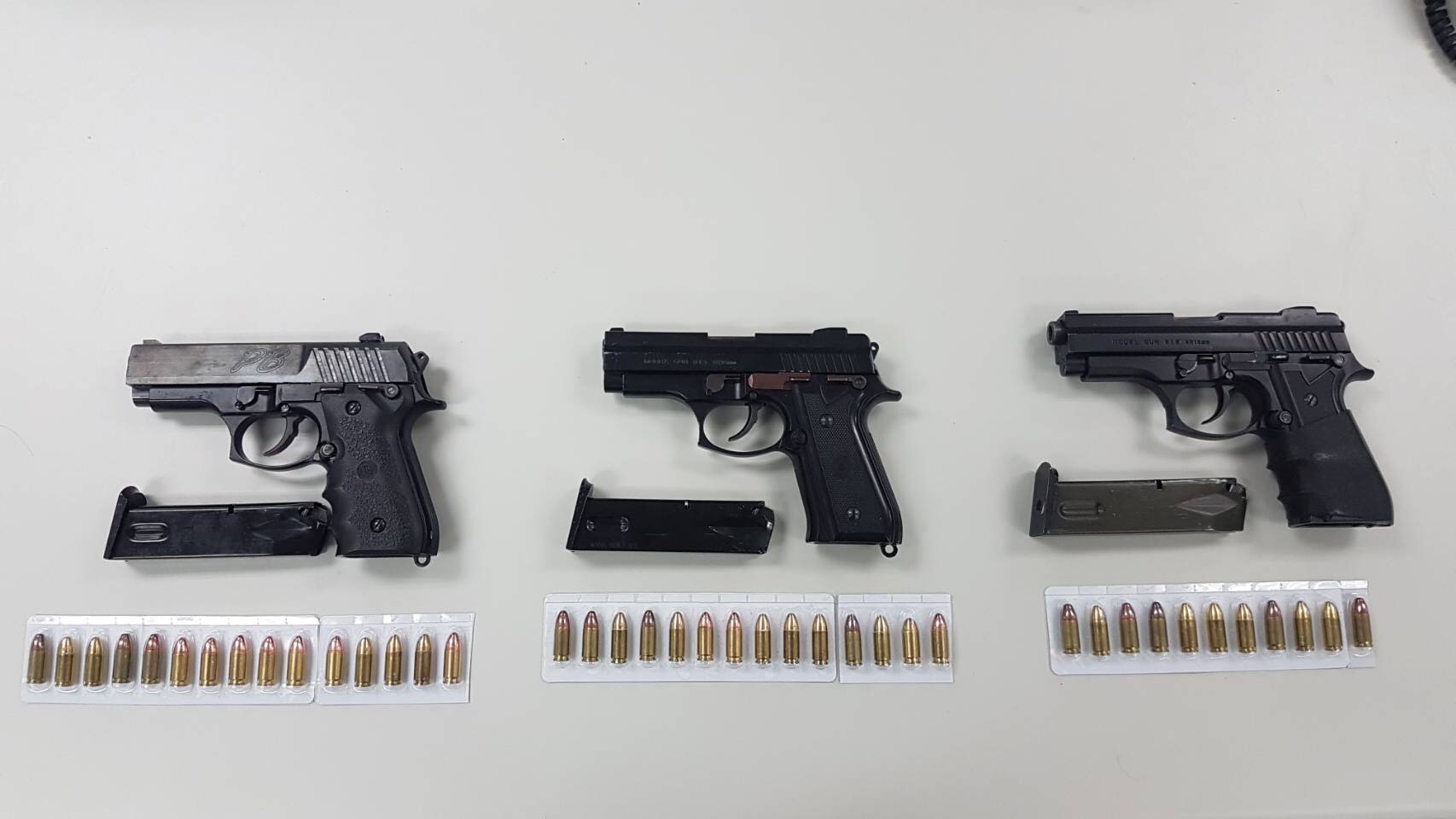 李嫌腰際緝獲的3枝改造手槍與附有彈匣及子彈40顆。（警方提供）